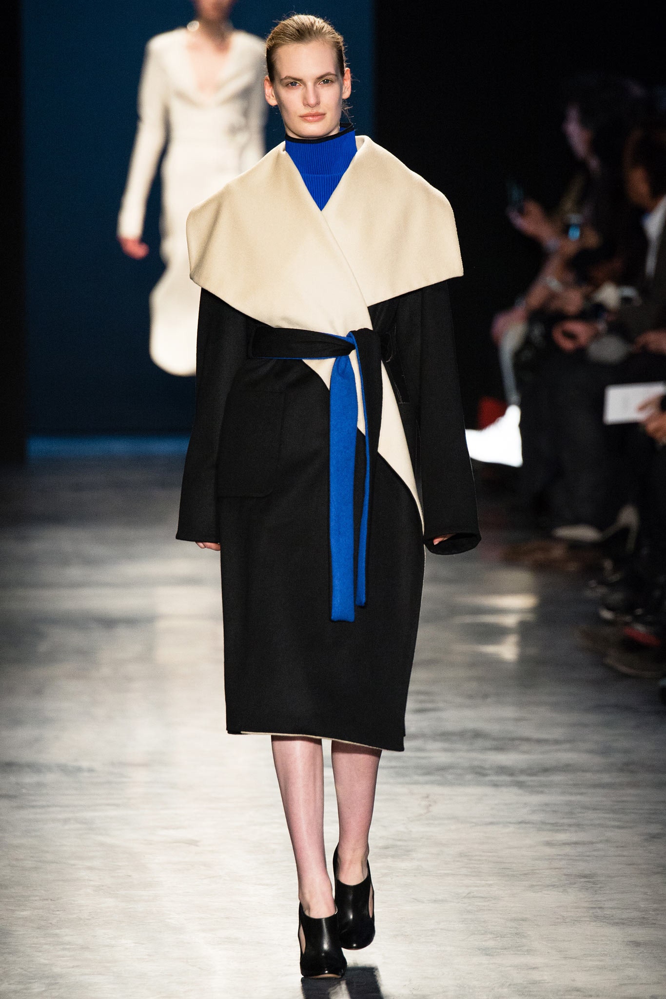 black and beige belted coat with blue top