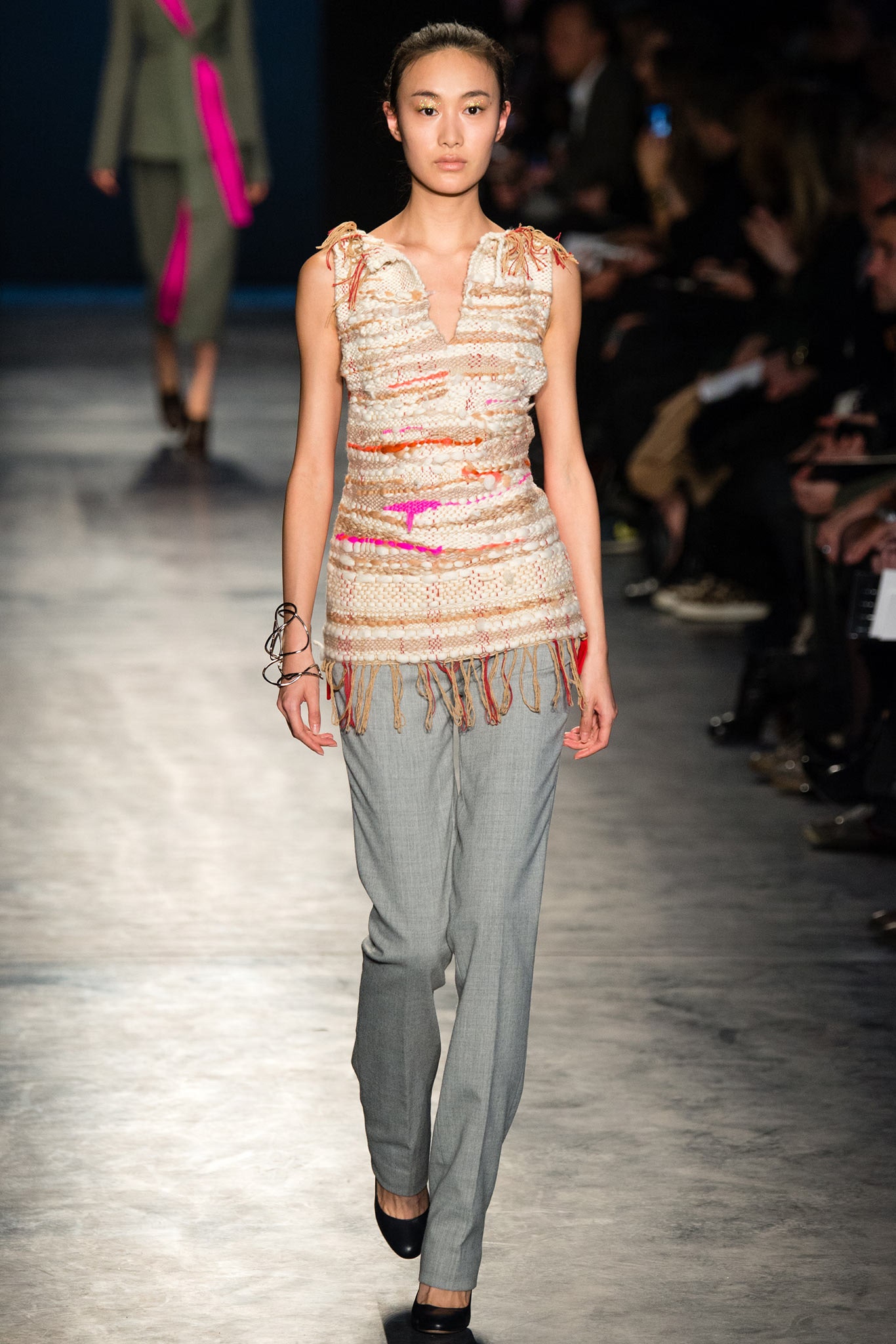 beige fringed sleeveless top with gray pants