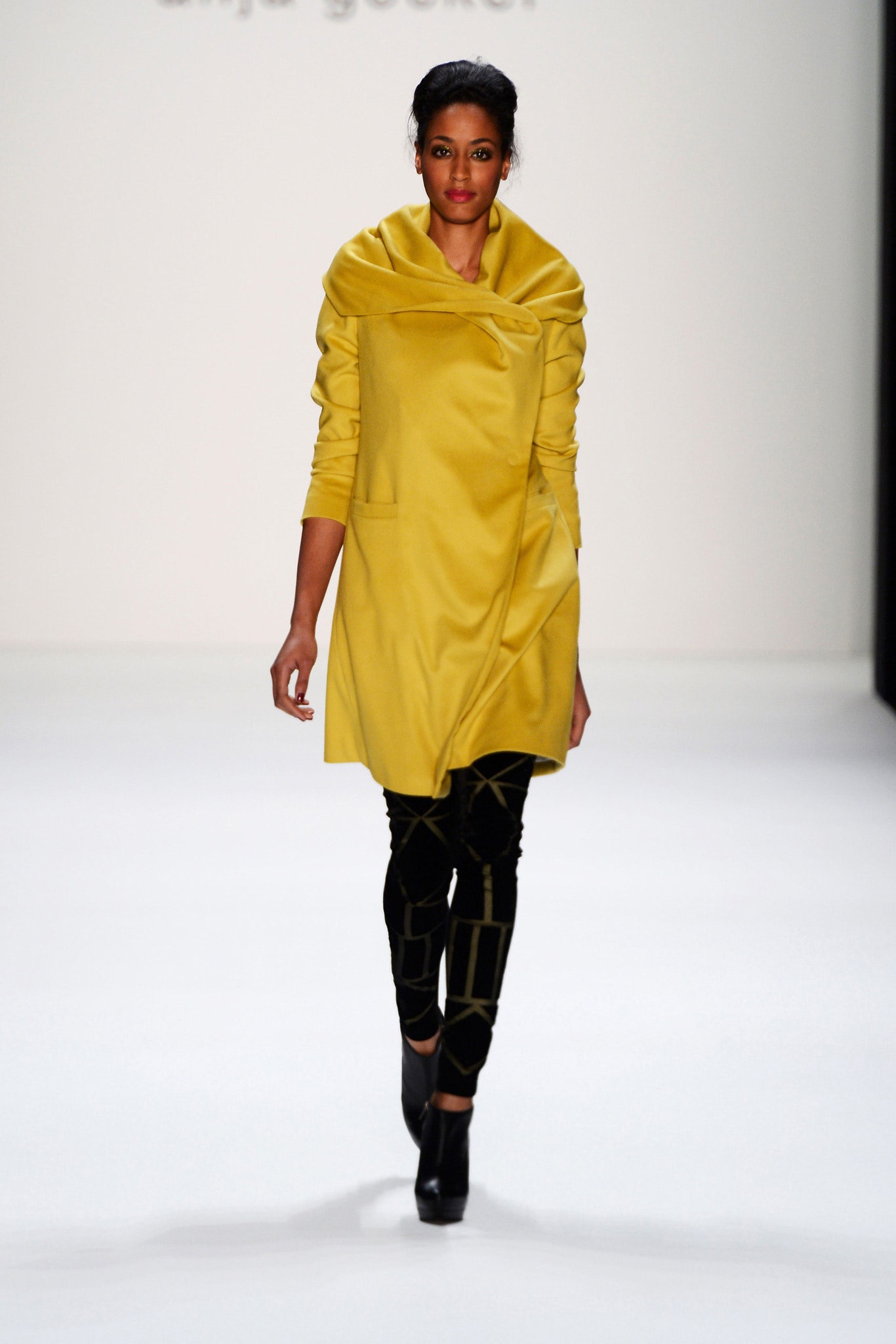 yellow relaxed coat with black fitted pants