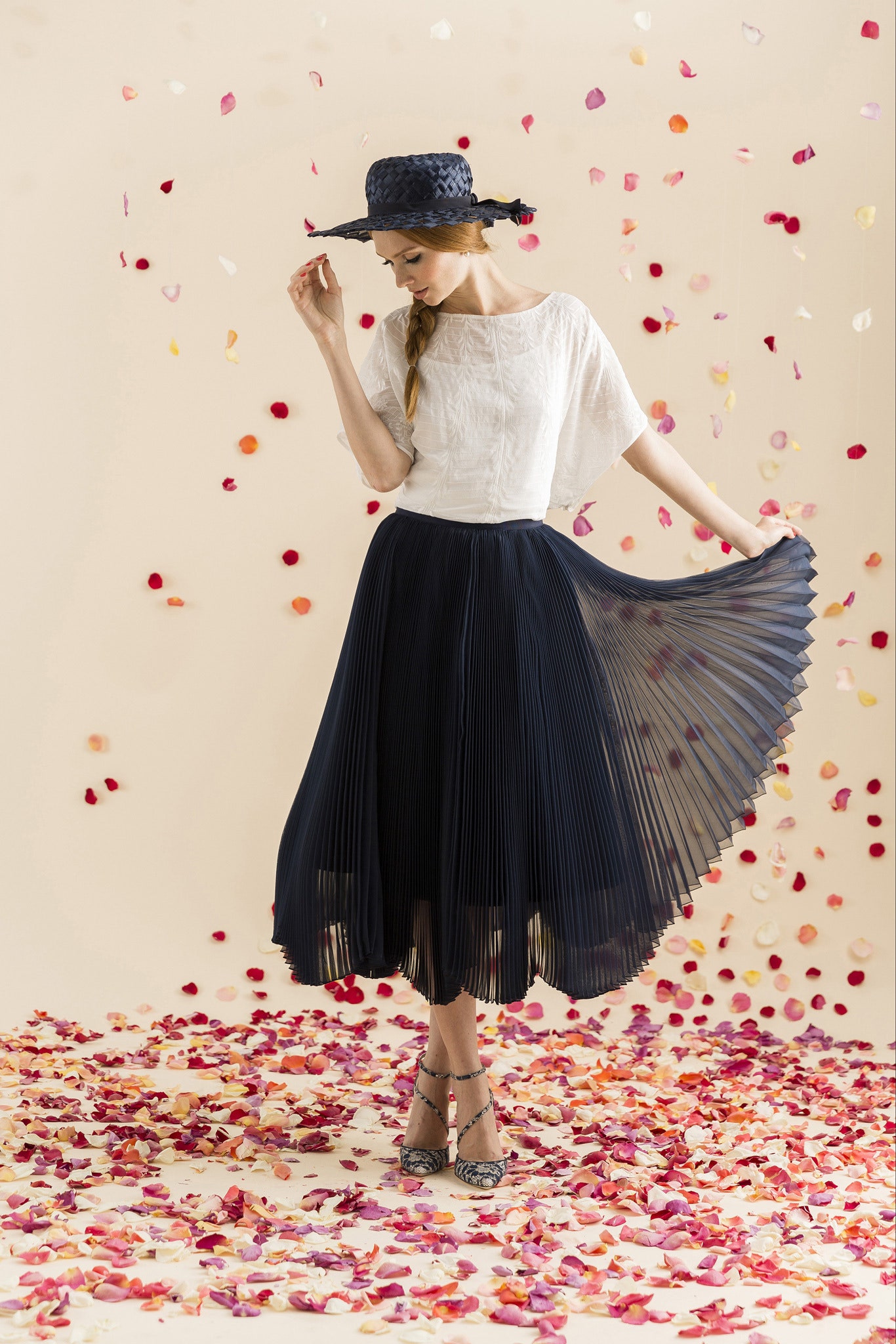 white relaxed top with navy pleated skirt
