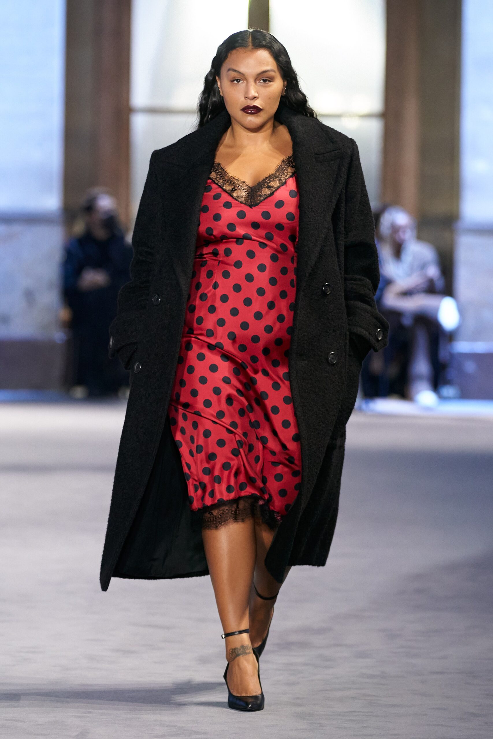 black wool coat and red polka-dot dress