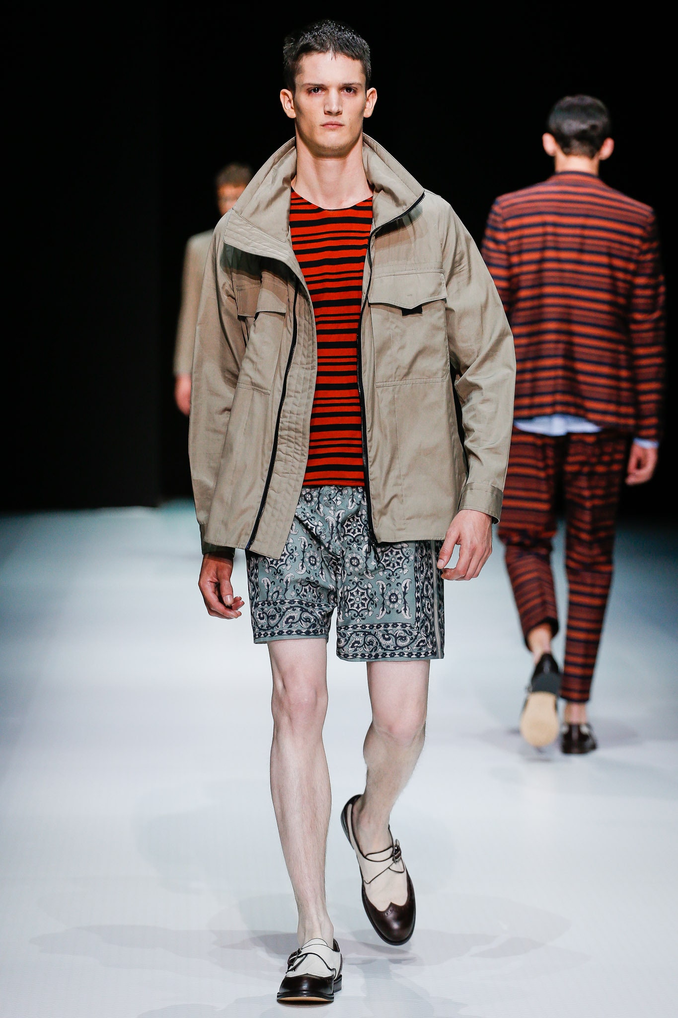 beige jacket with striped shirt and blue shorts