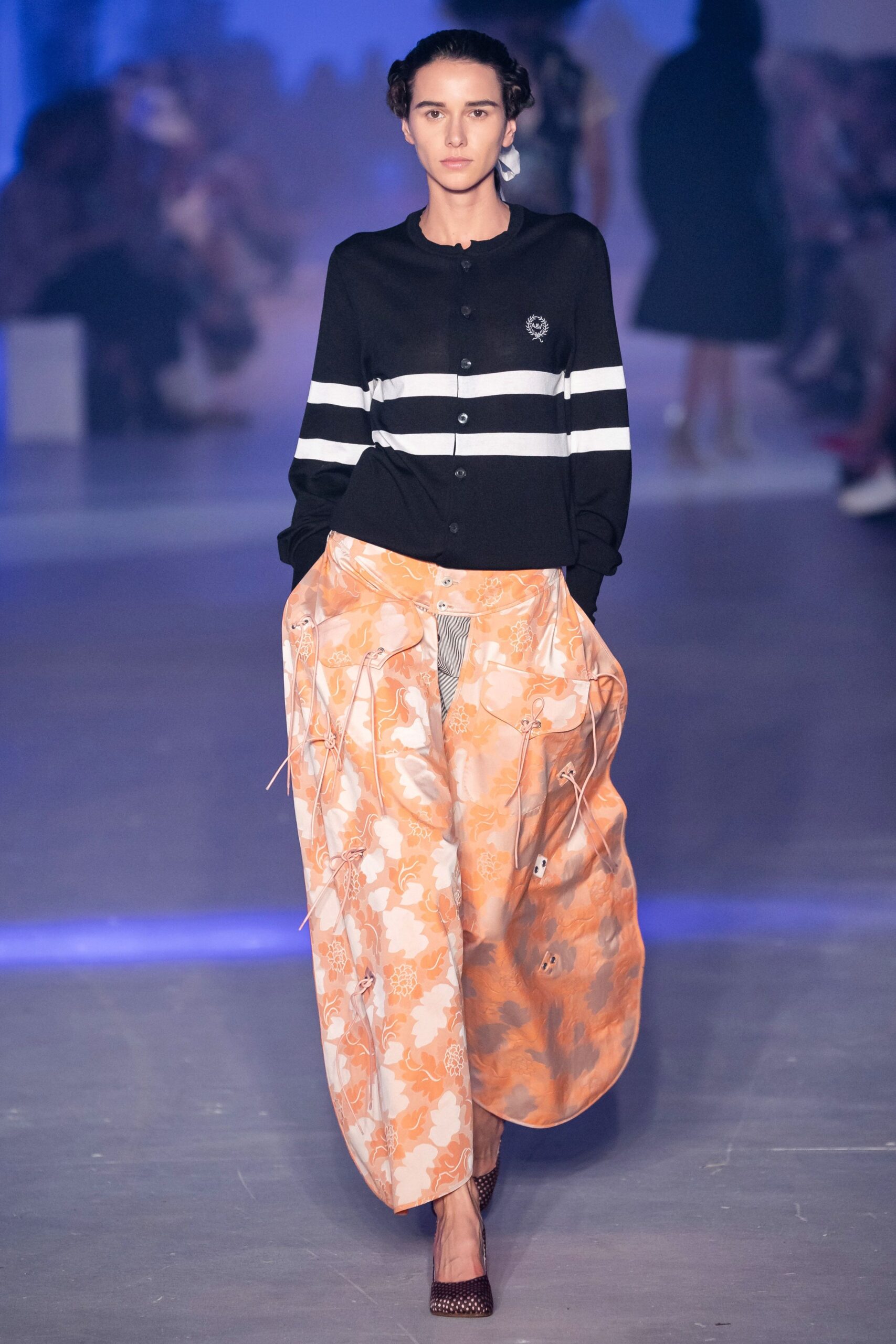 black cardigan and orange pants