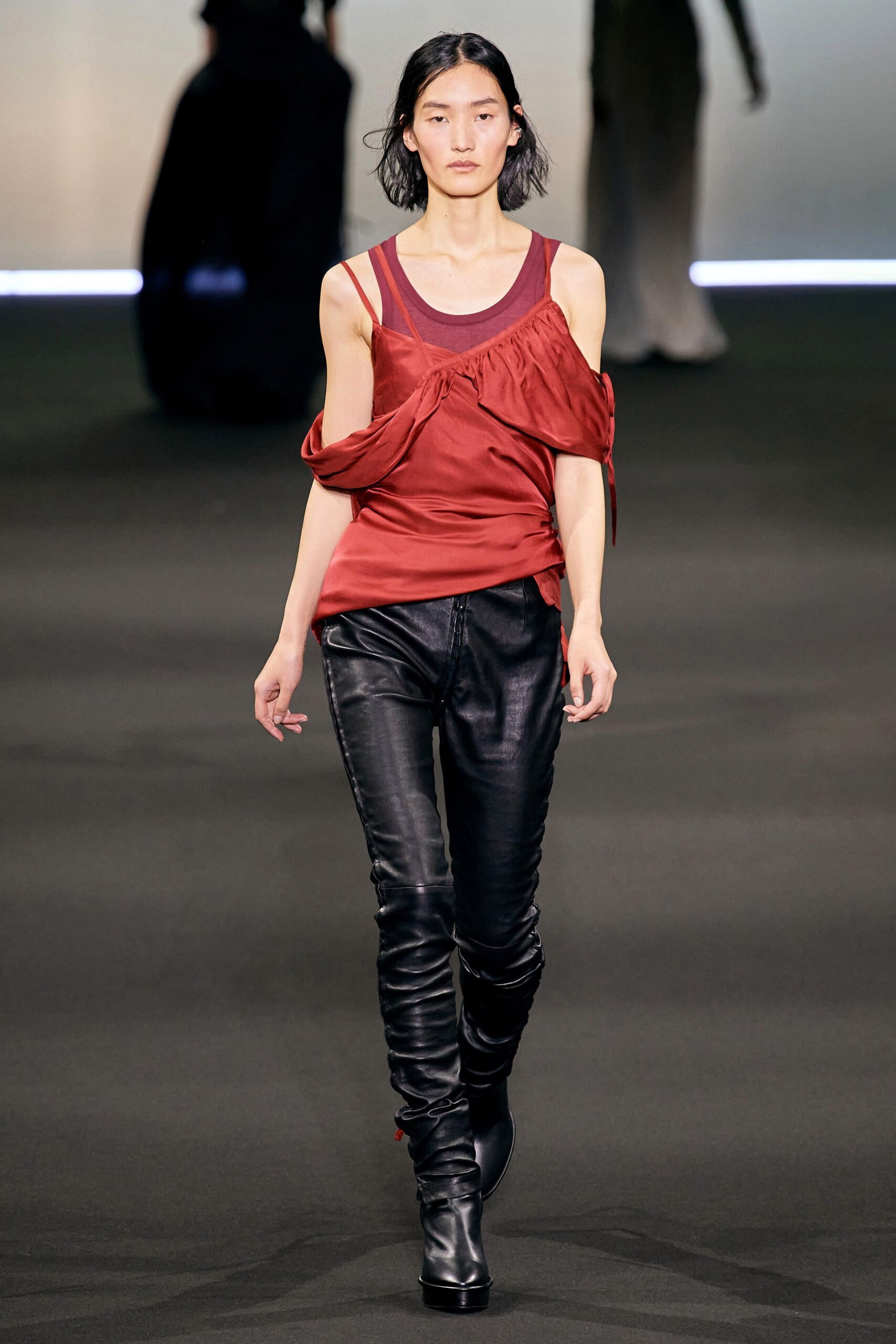 red silk off-shoulder top with black leather pants