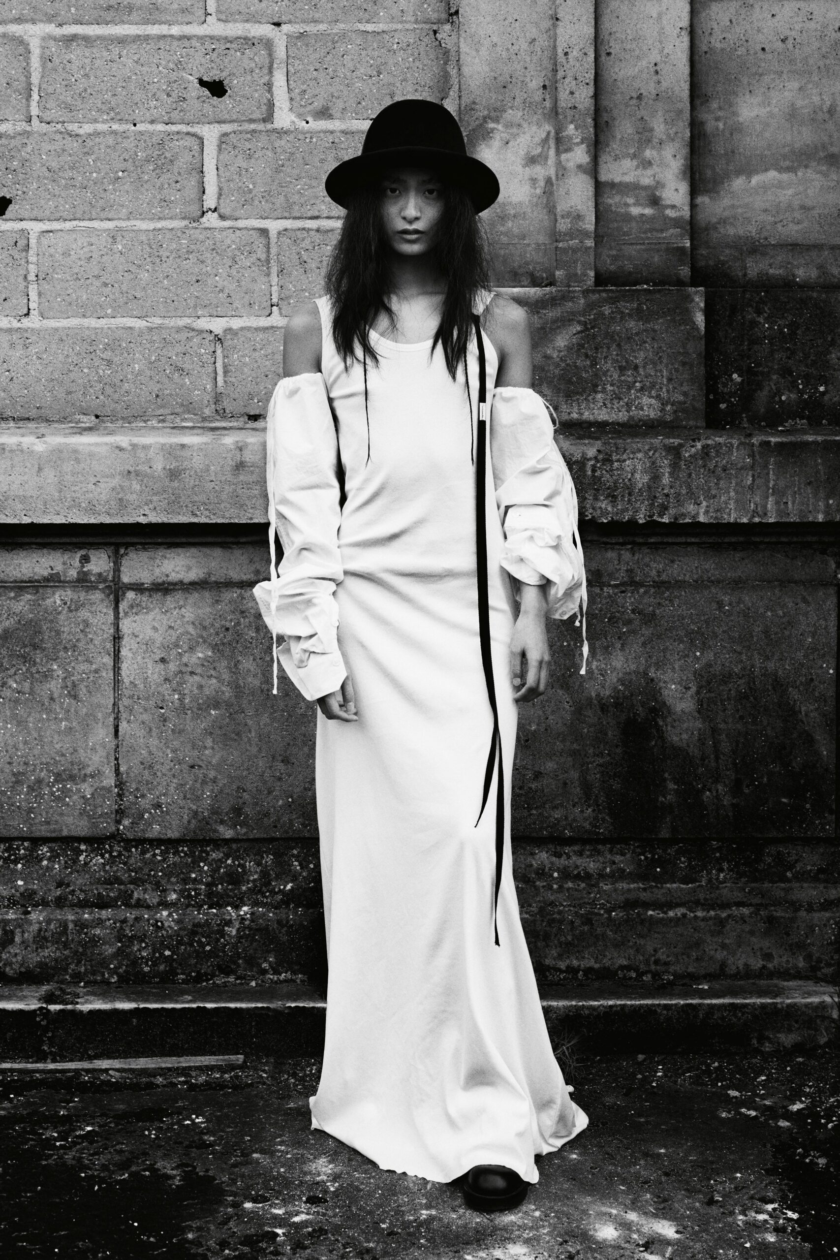 white off-shoulder maxi dress with black hat