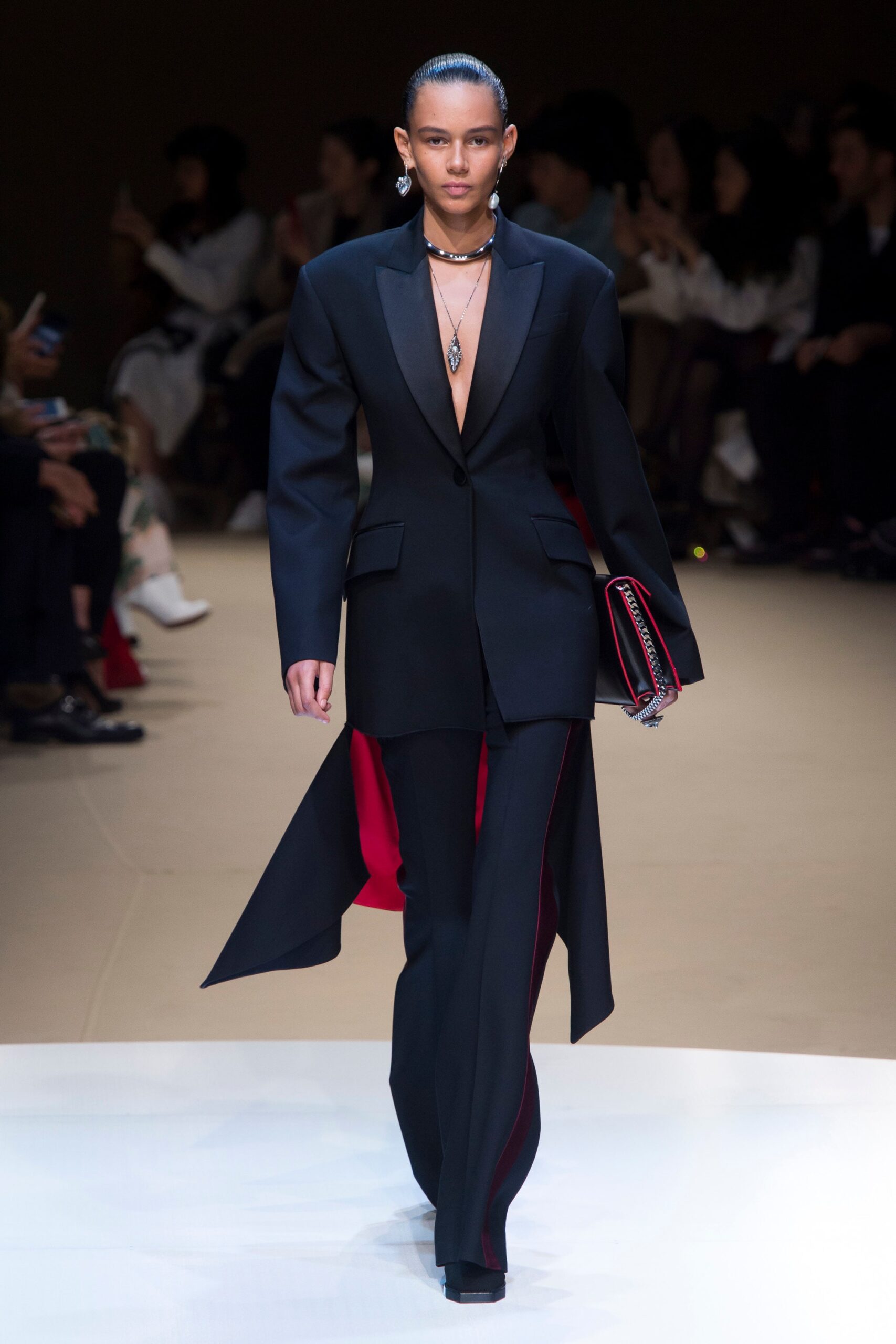 black tailored suit with red clutch