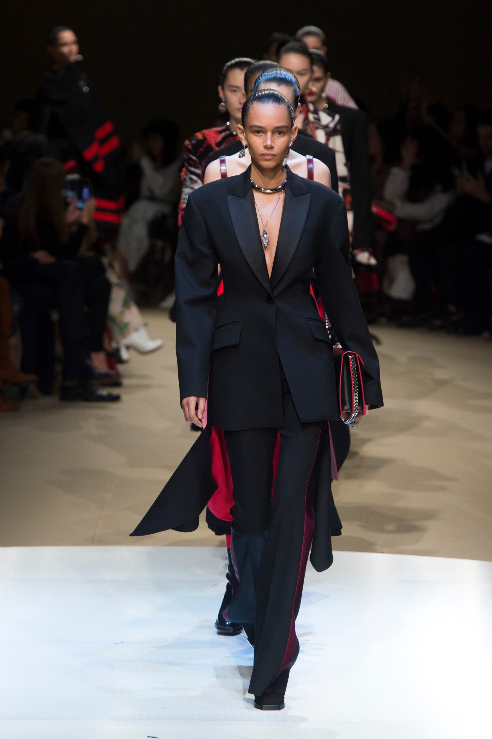 black tailored suit with red bag