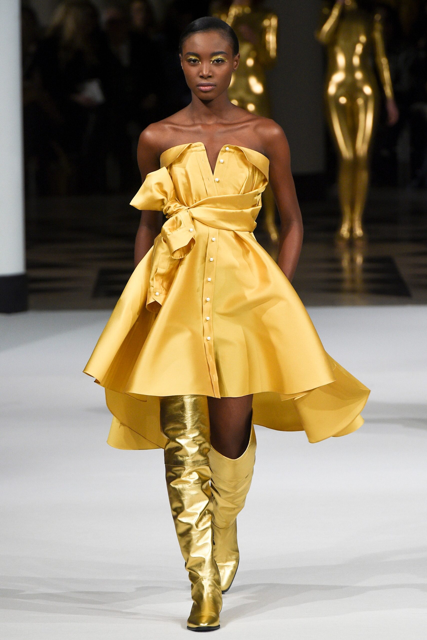 yellow silk strapless dress with gold boots