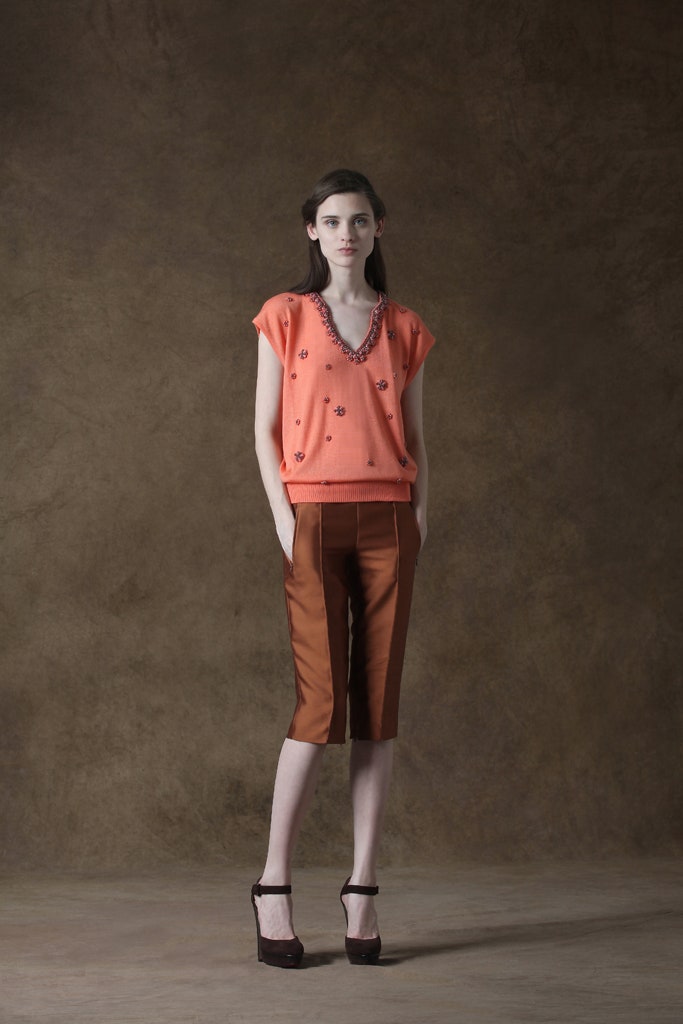 orange embroidered top with brown pants