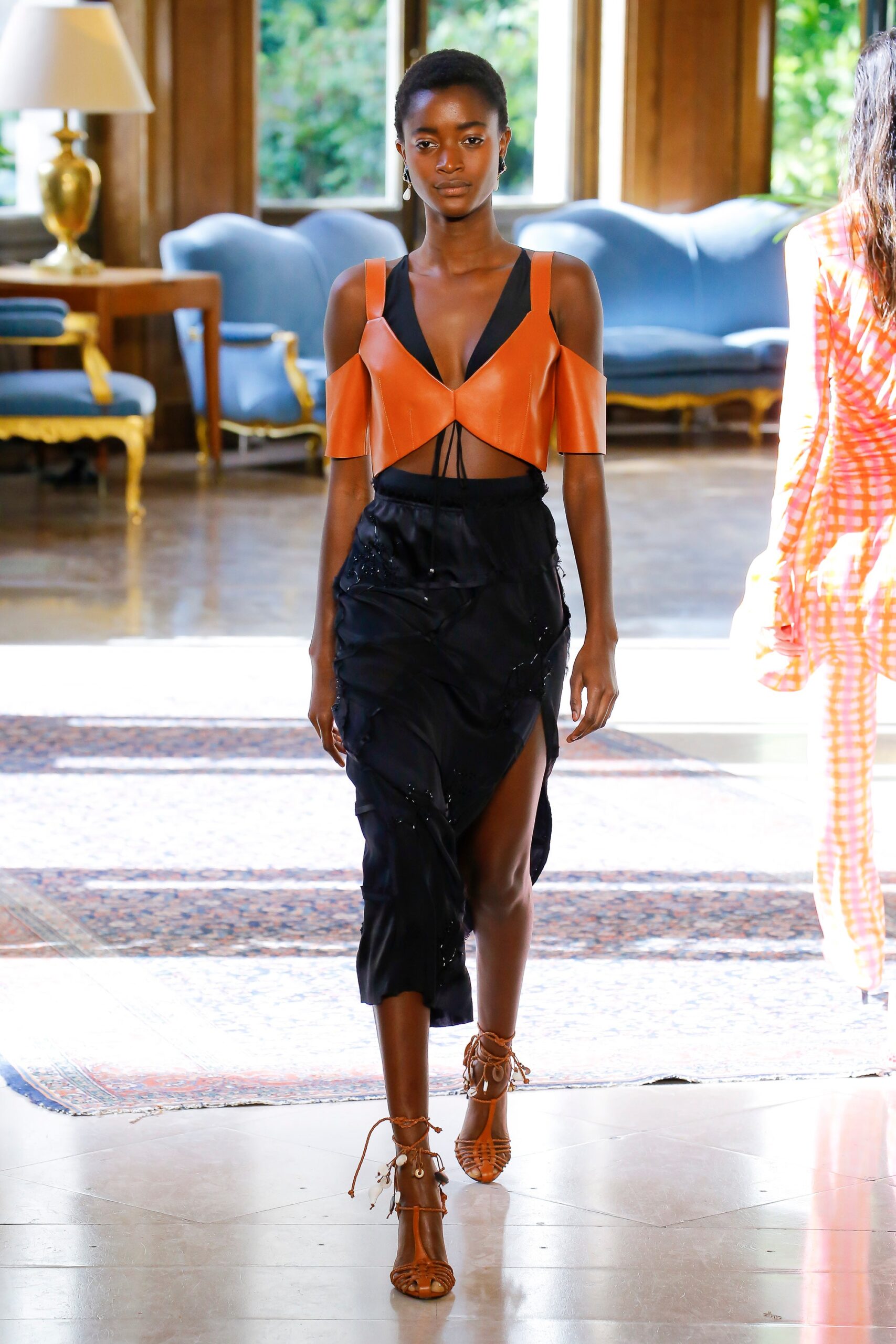 orange silk off-shoulder top and black midi skirt