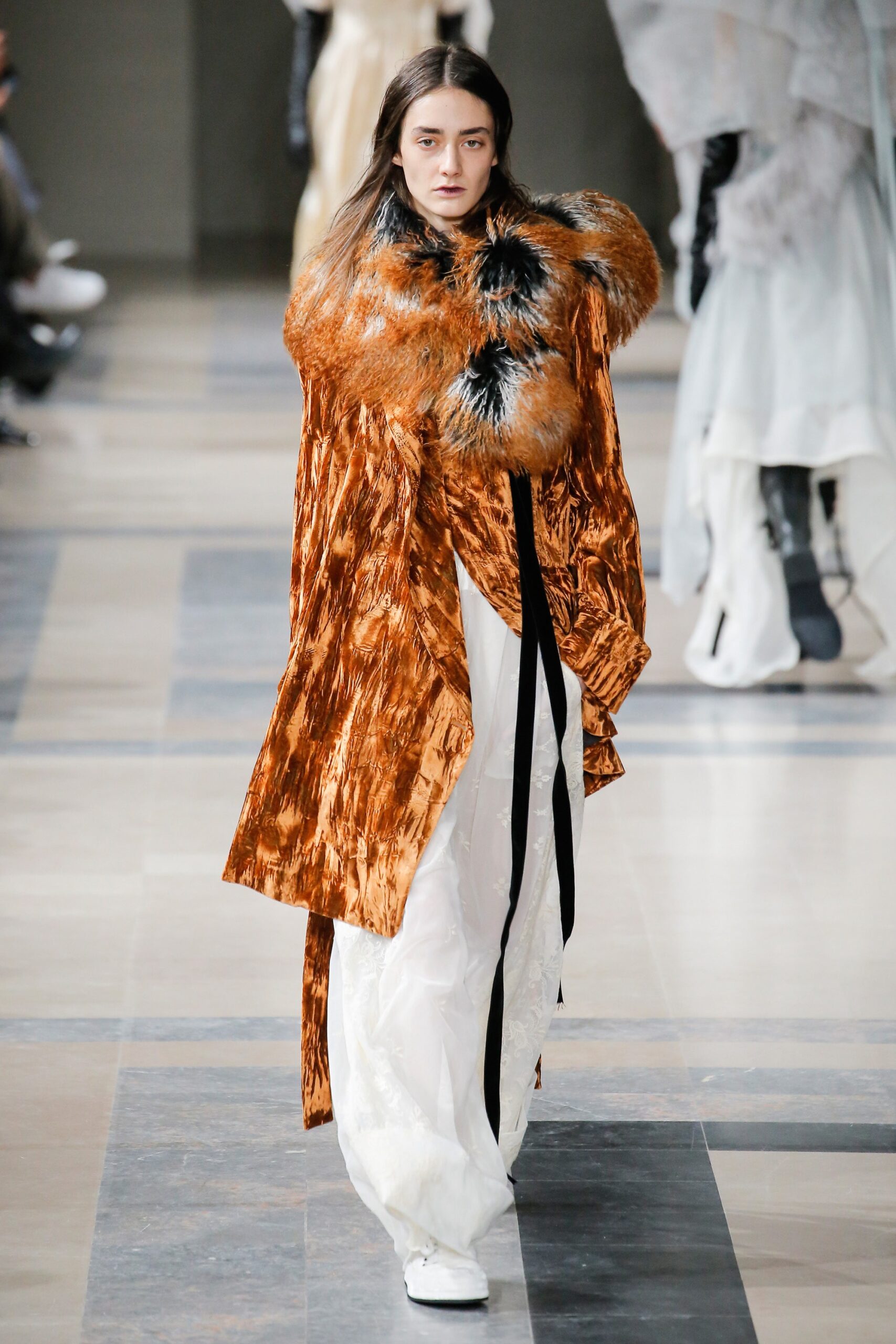 orange silk draped coat with white pants