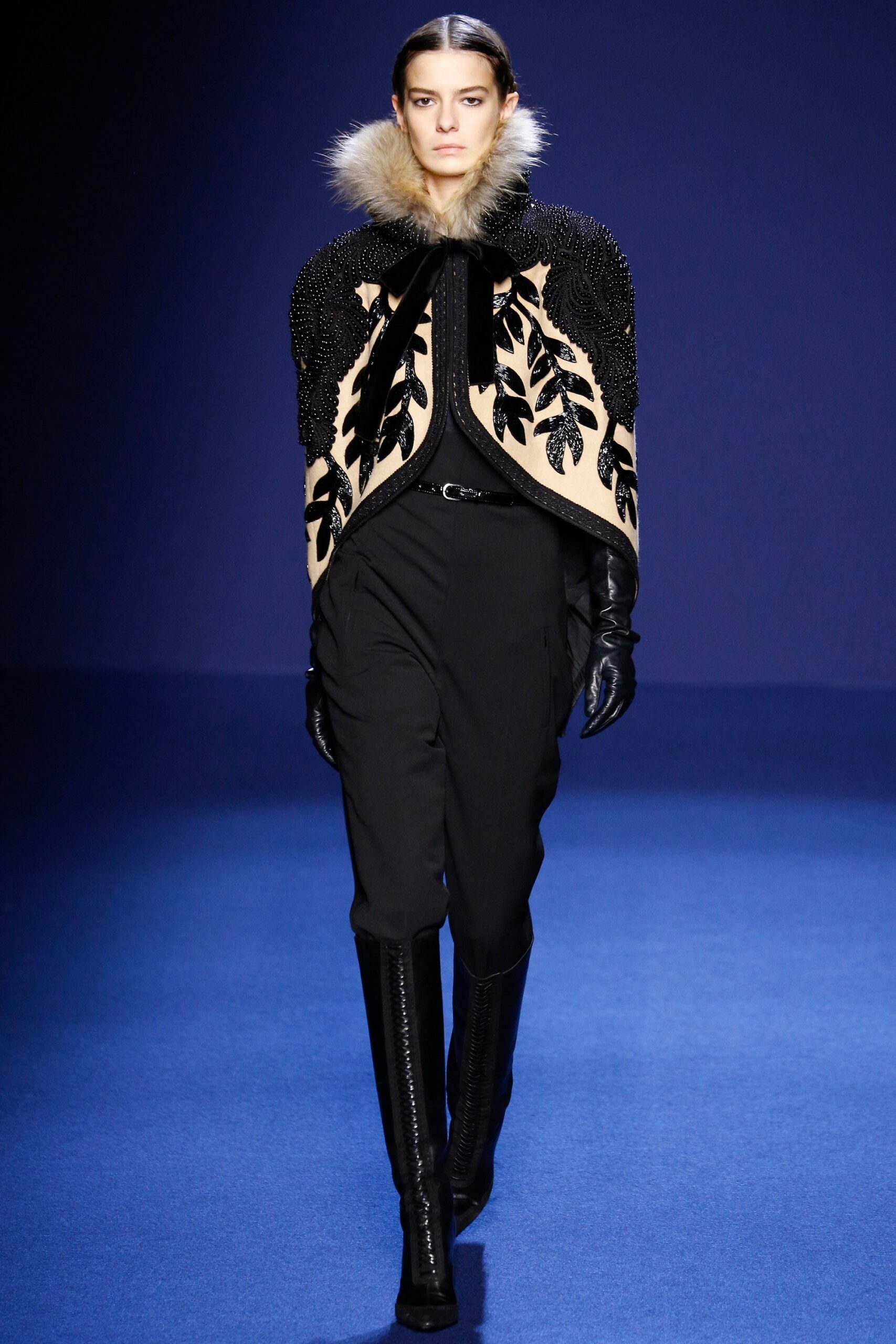 beige embroidered cape with black pants