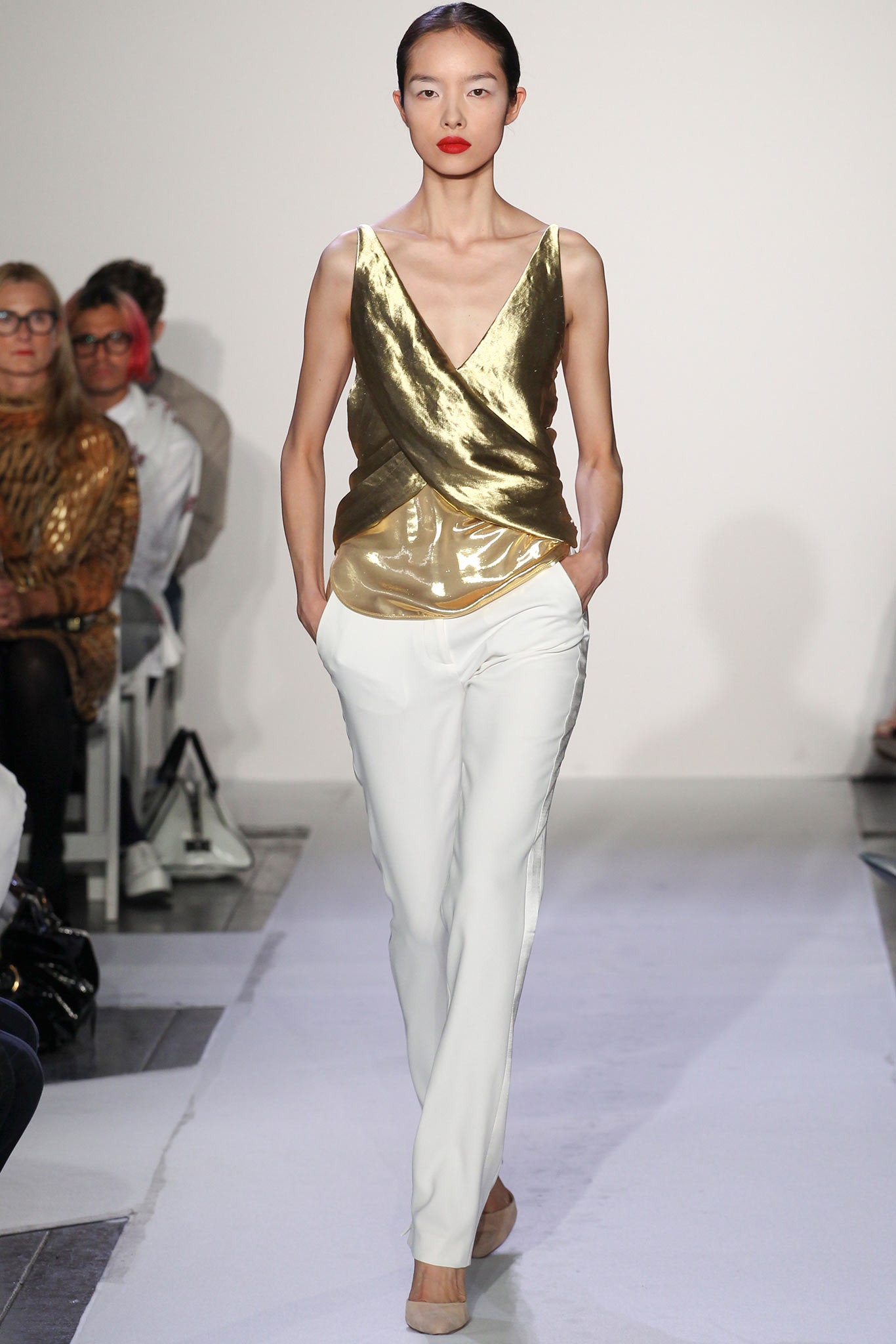 gold silk sleeveless top and white tailored pants