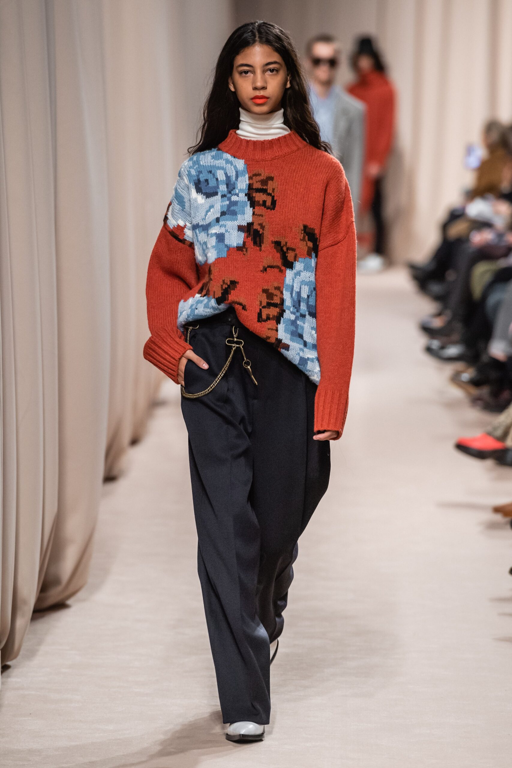 relaxed red sweater with printed design and tailored black pants