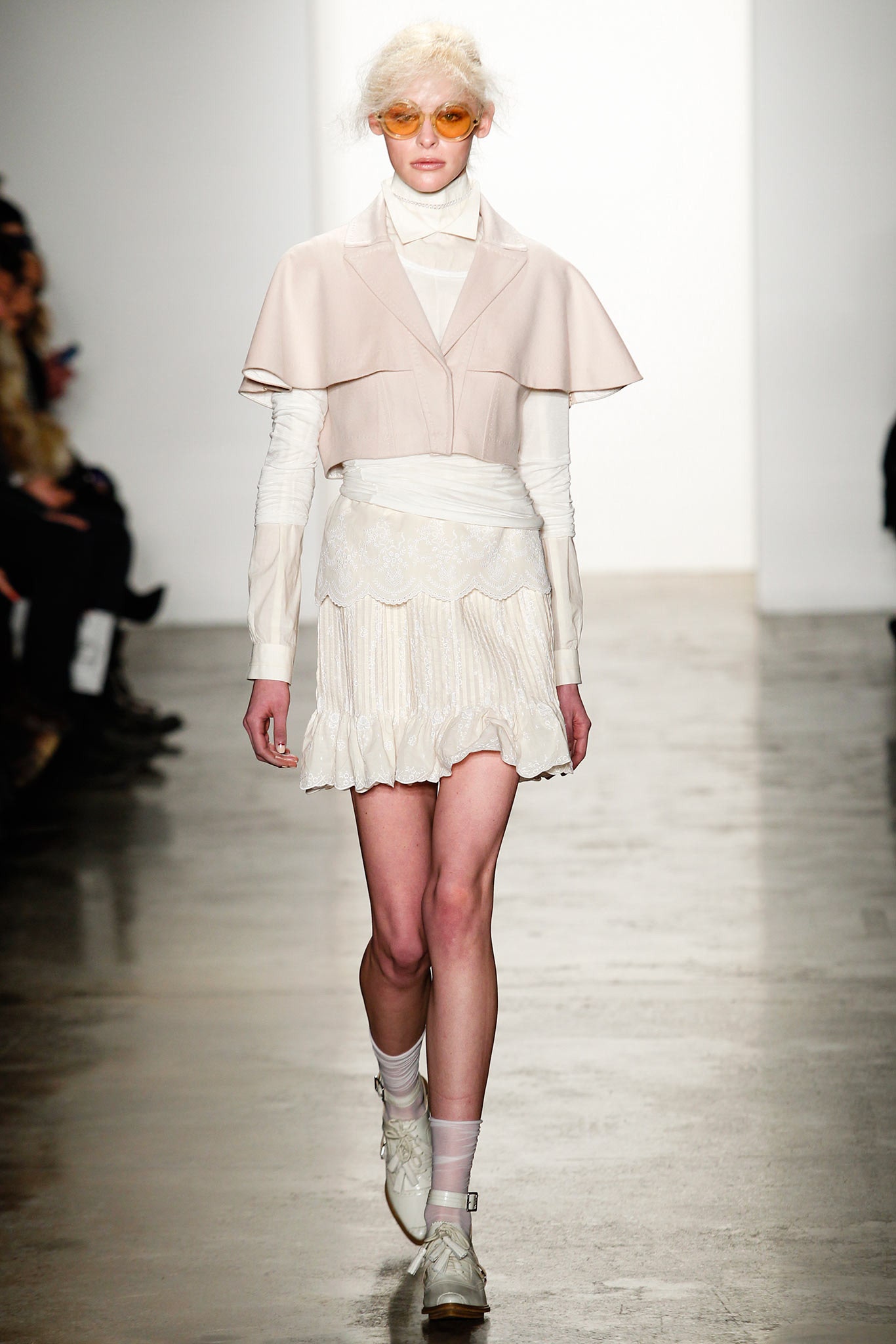 beige cape and white pleated dress