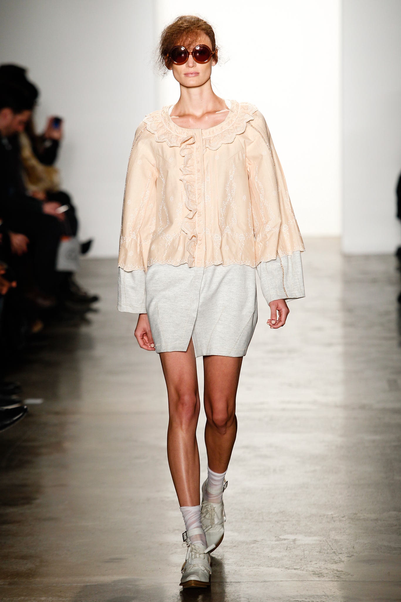 peach ruffled top with gray shorts