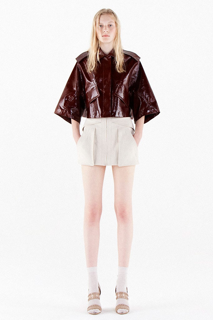 red vinyl fitted jacket and beige tailored shorts