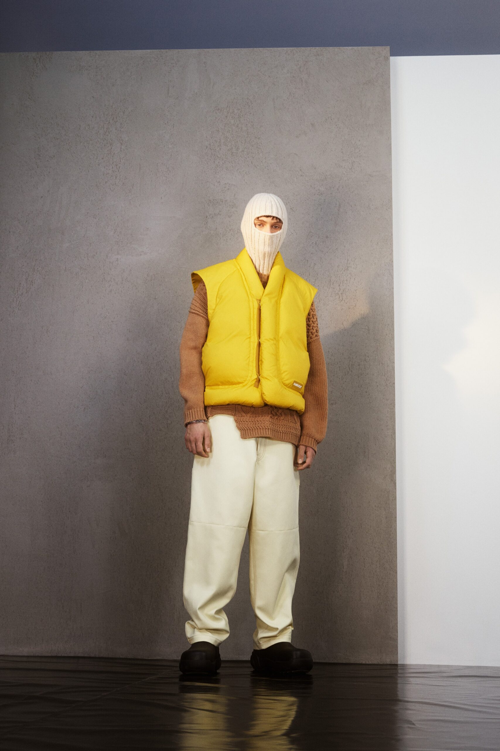 yellow vest brown sweater white pants