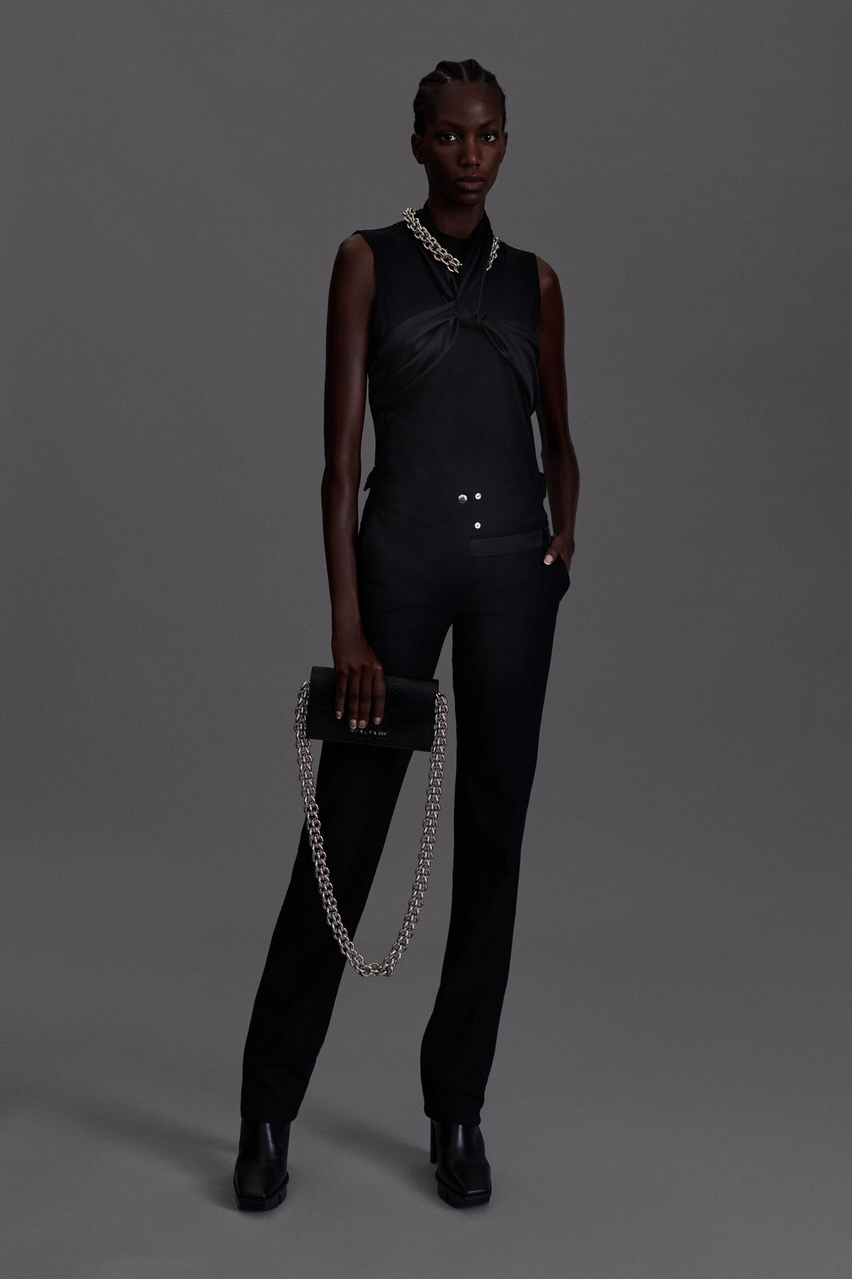 black fitted jumpsuit with clutch