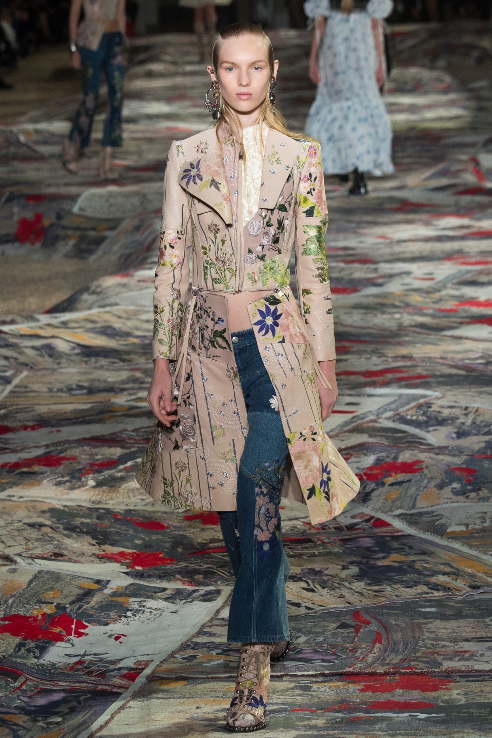 beige embroidered coat and blue jeans