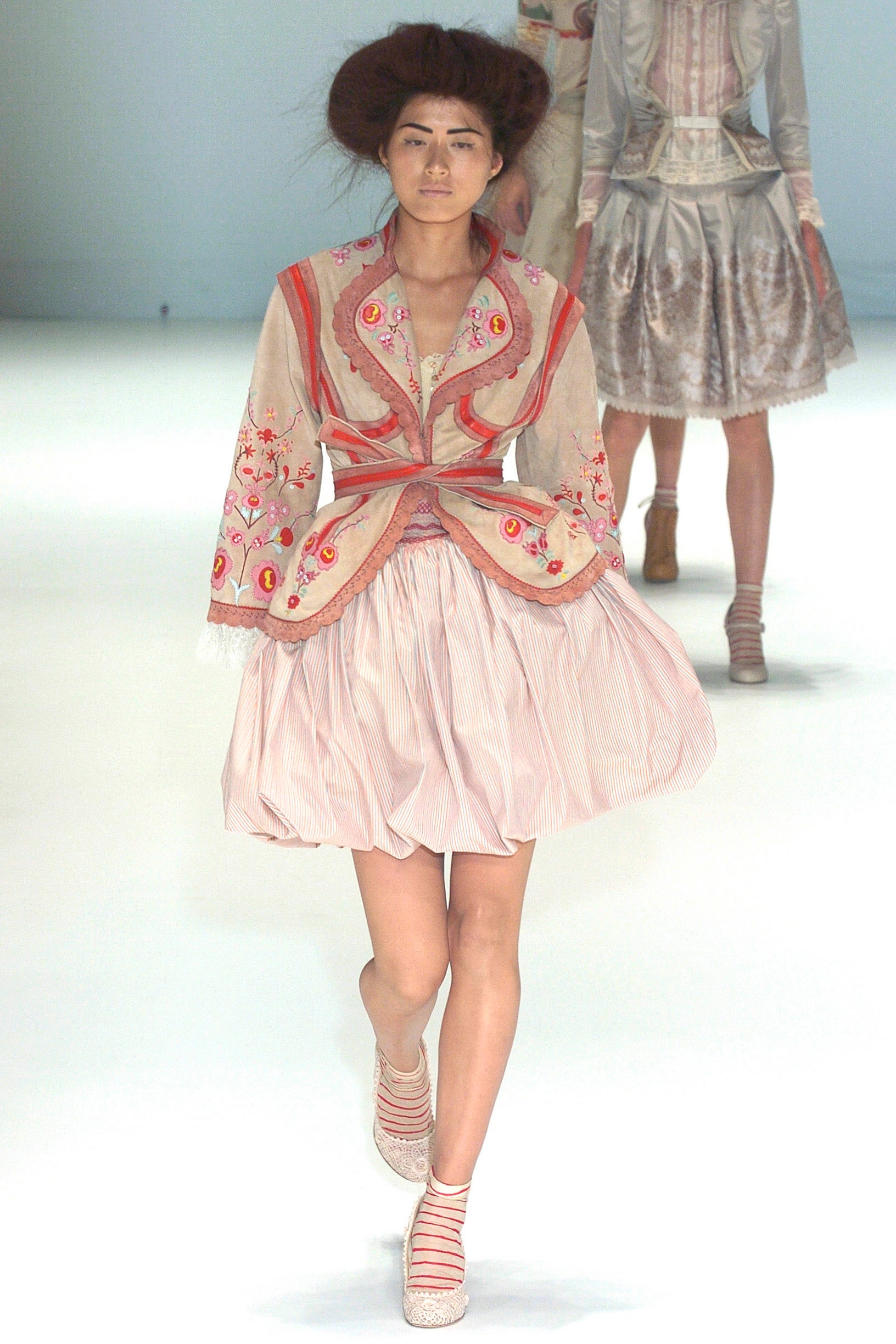 beige embroidered jacket and pink skirt