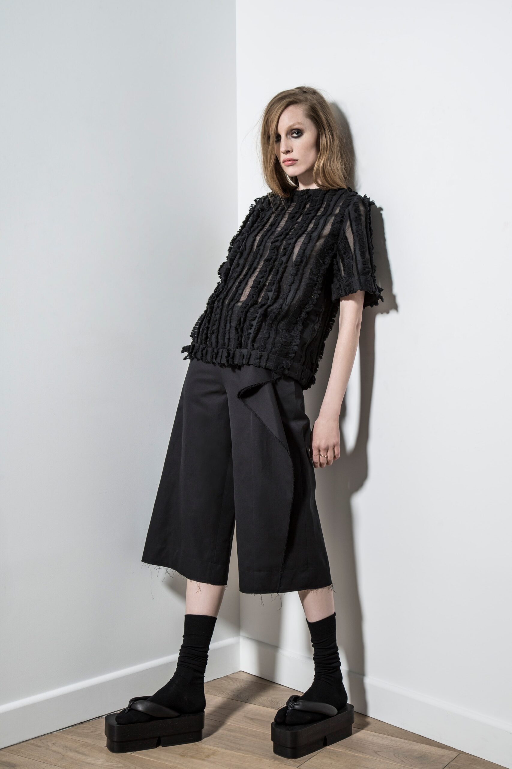 black fringed top and wide-leg pants