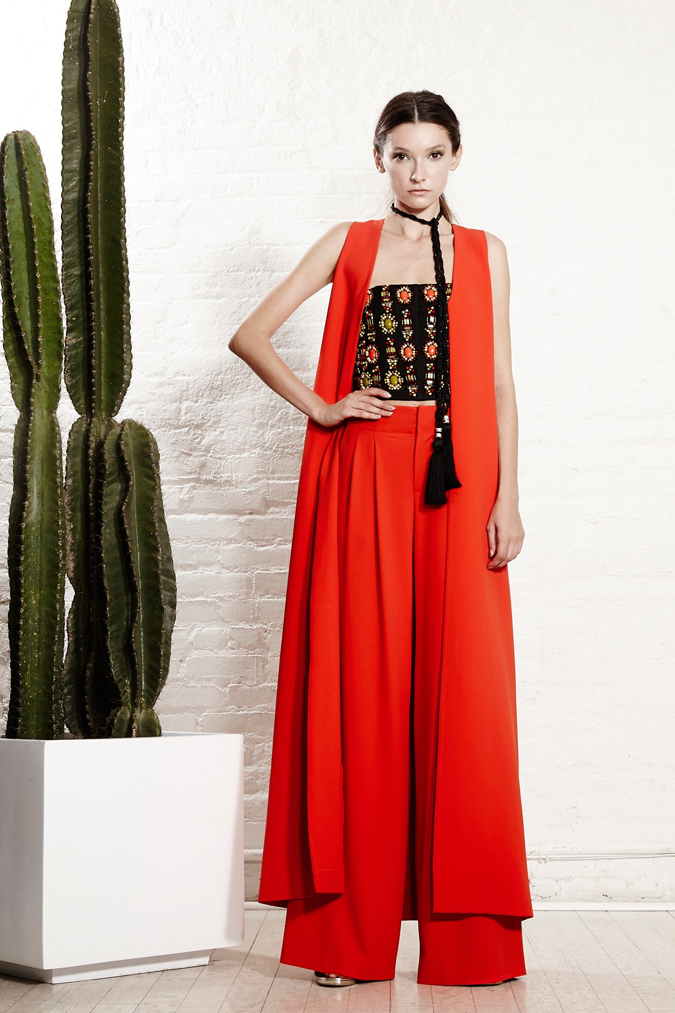 black embroidered sleeveless top with red pants