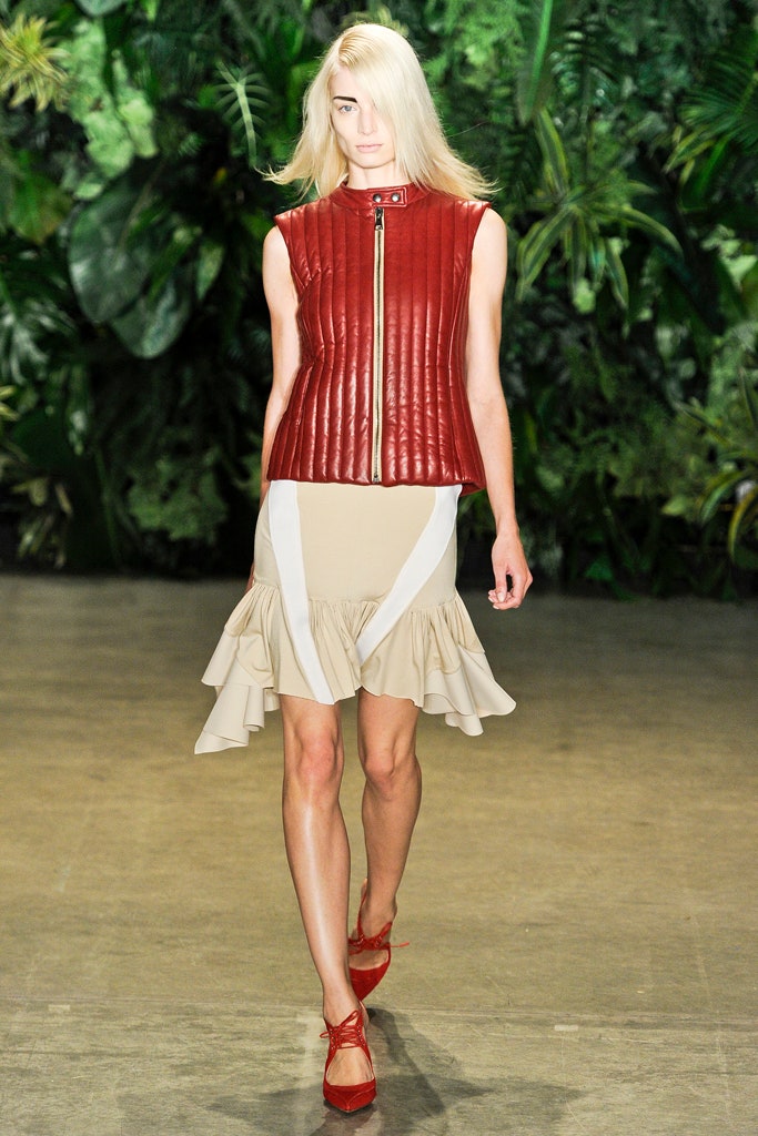 red leather sleeveless top and beige flared skirt