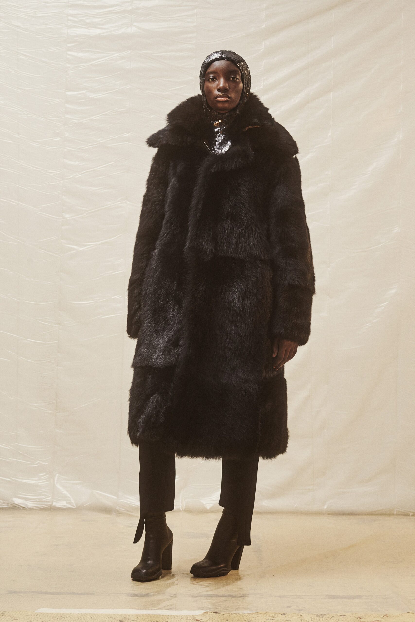 black faux-fur coat with slim pants