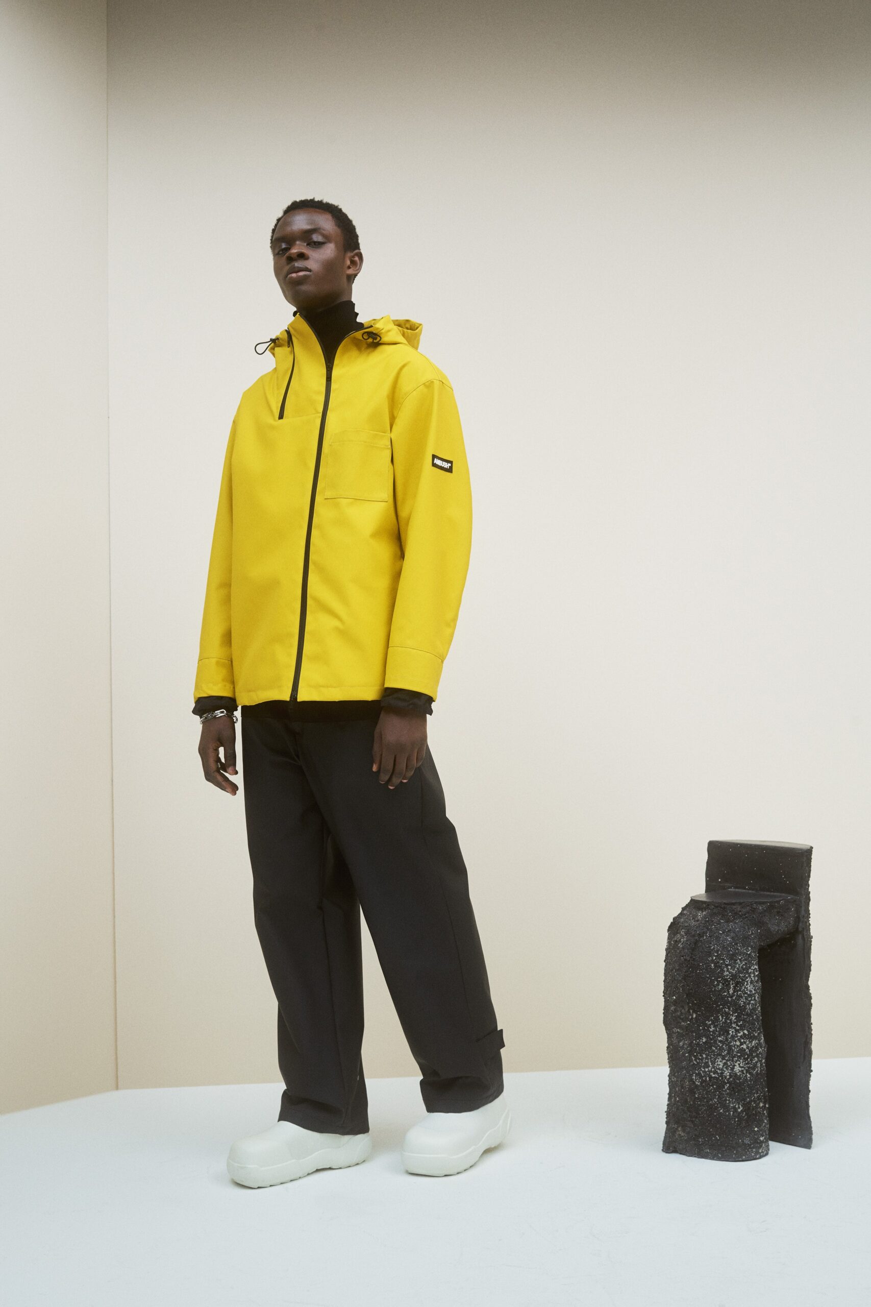 yellow vinyl hooded jacket and black pants