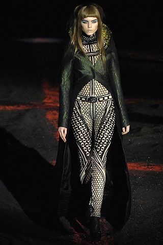 black and white mesh catsuit with green cape