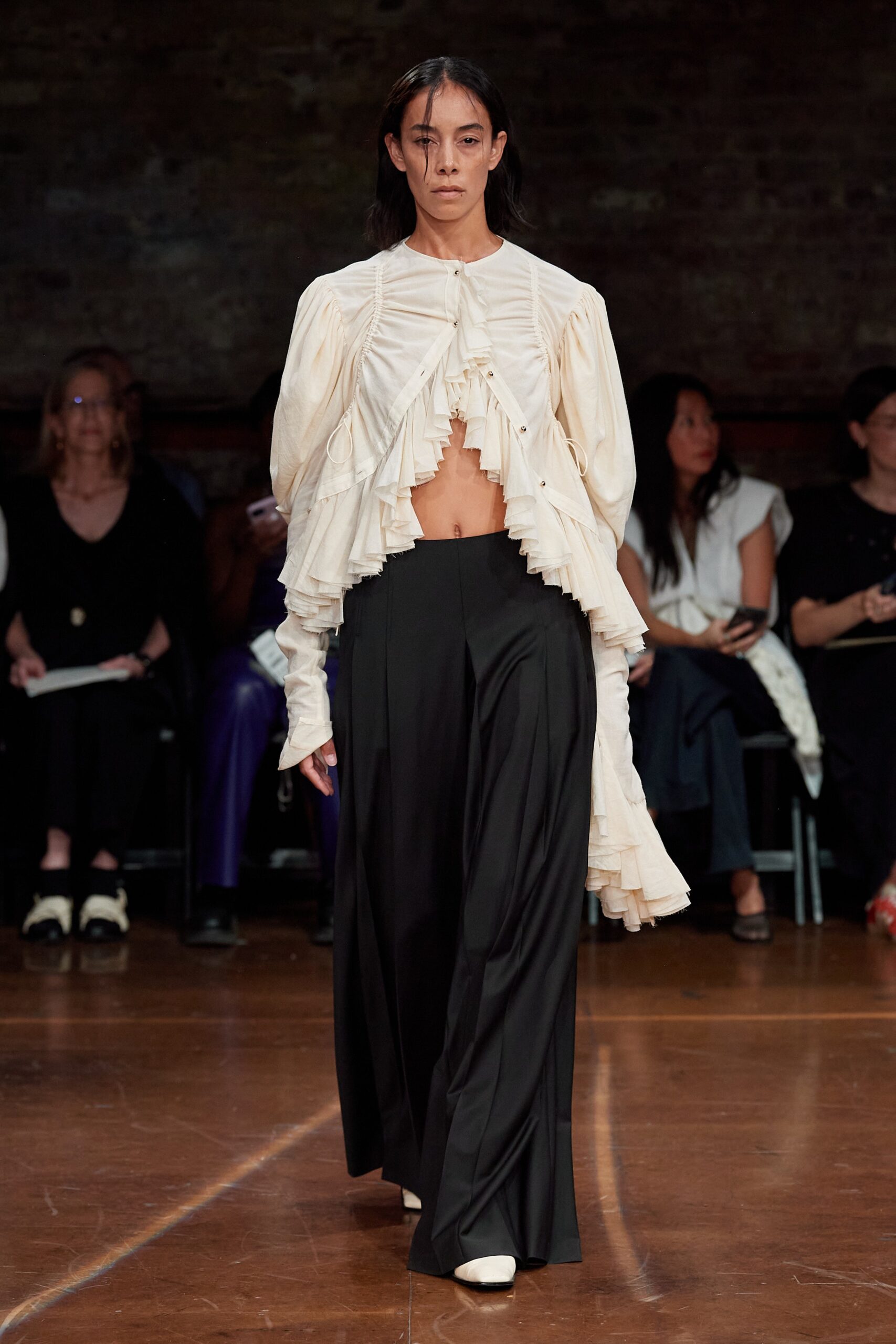 white ruffled blouse and black wide-leg pants