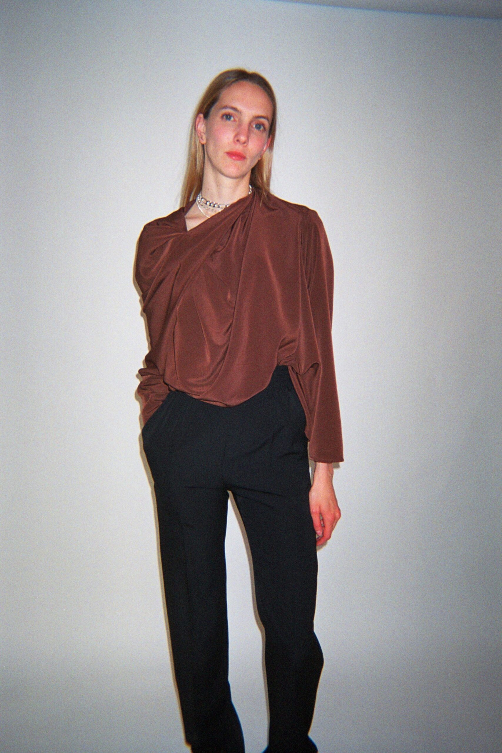 brown draped top with black pants