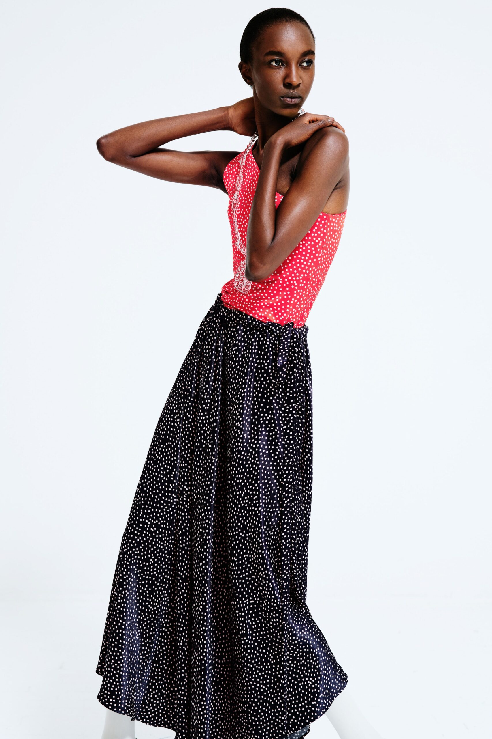 red polka-dot top with black skirt