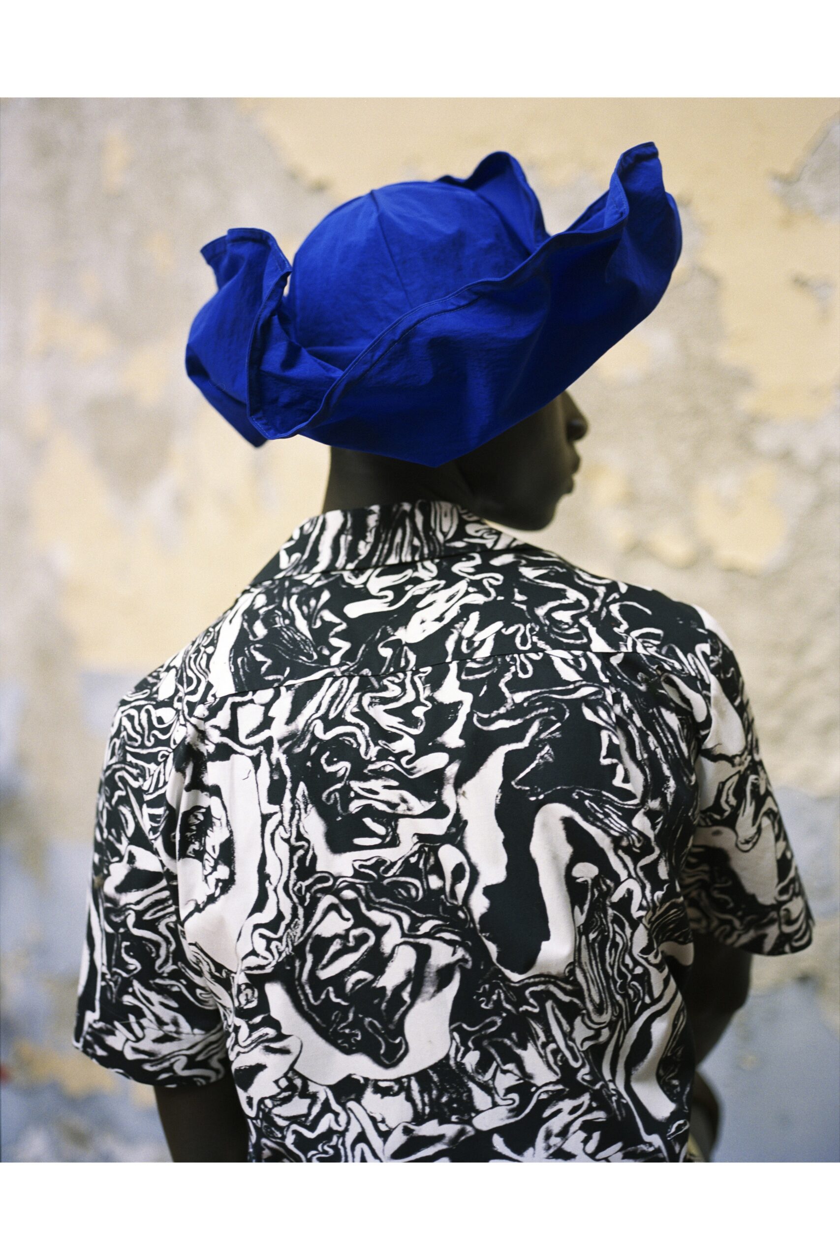 black and white printed shirt with blue hat