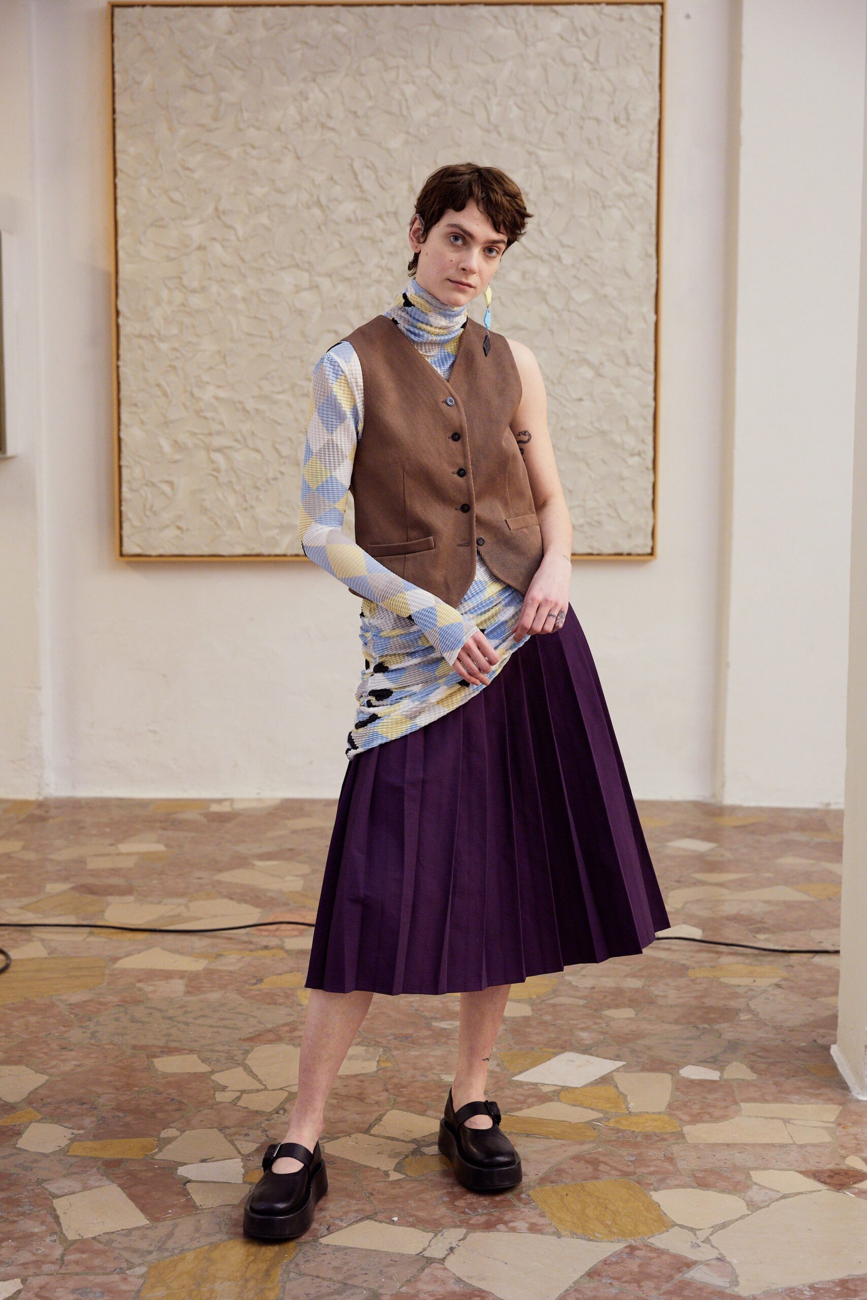 brown vest blue striped top purple pleated skirt