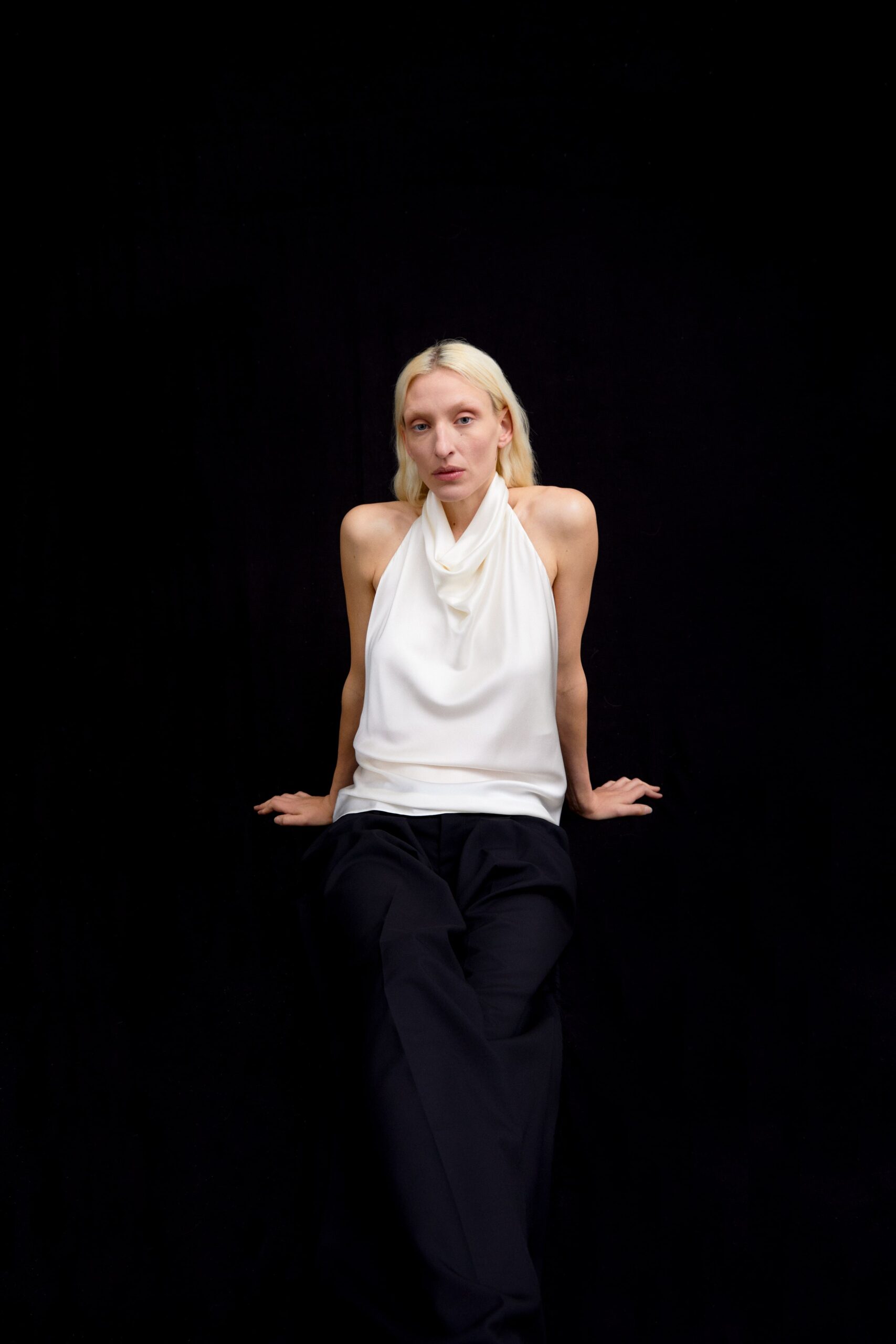 white silk sleeveless top and black pants