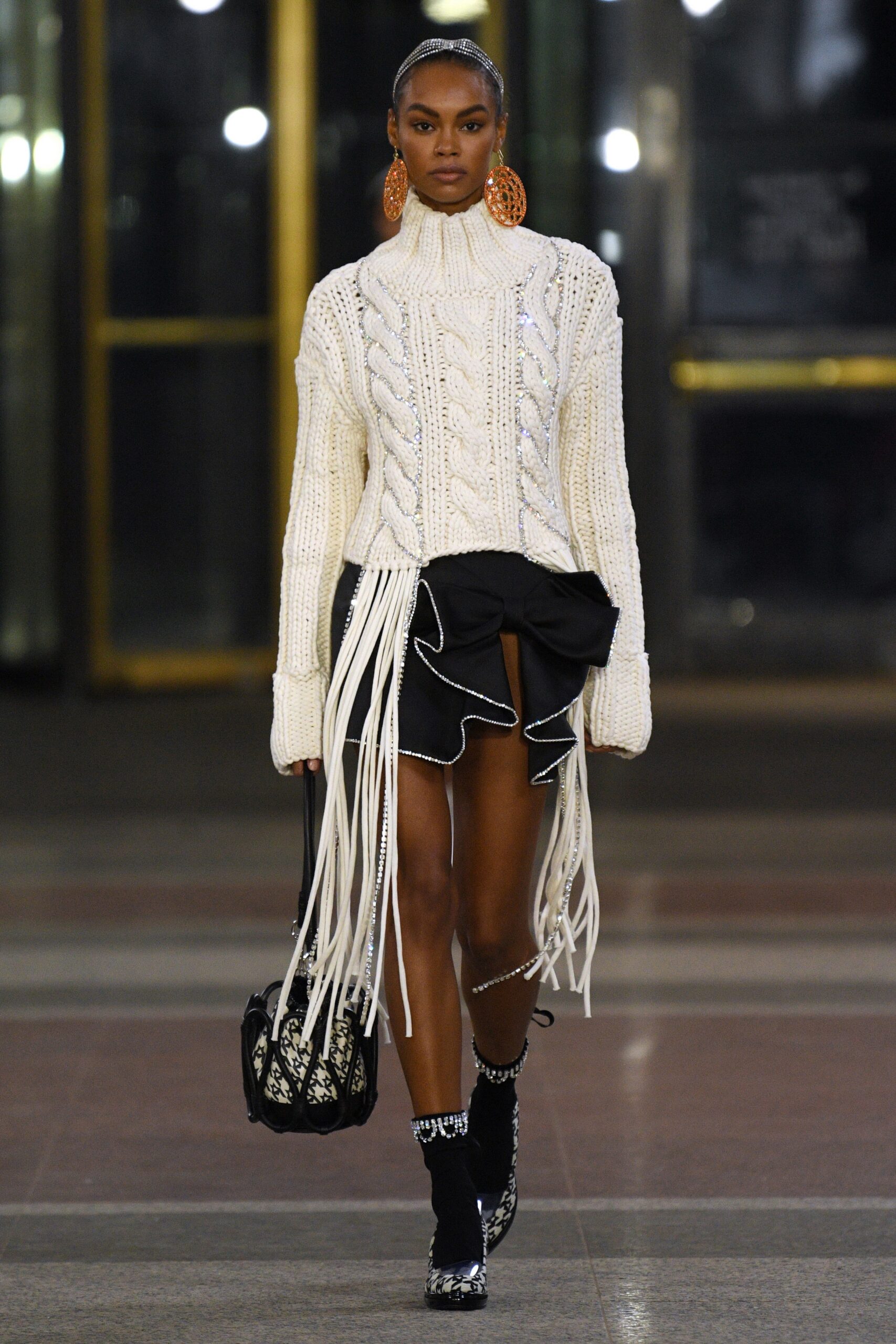 white fitted sweater with fringes and black ruffled skirt