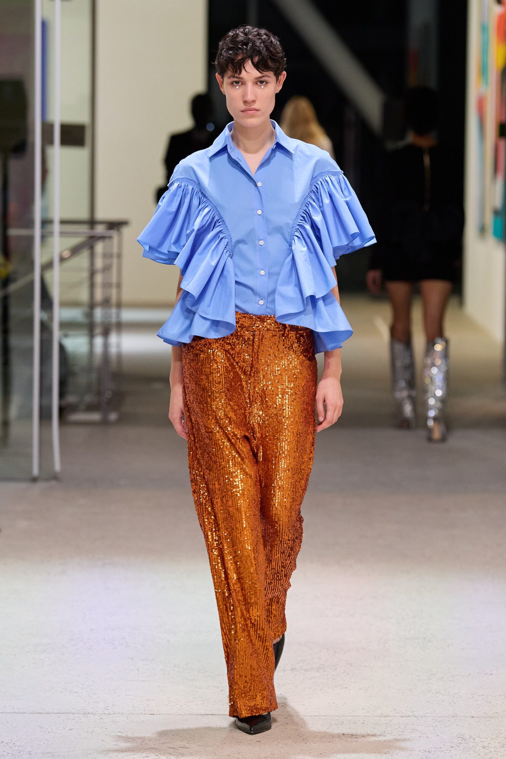 blue ruffled shirt and orange sequin pants
