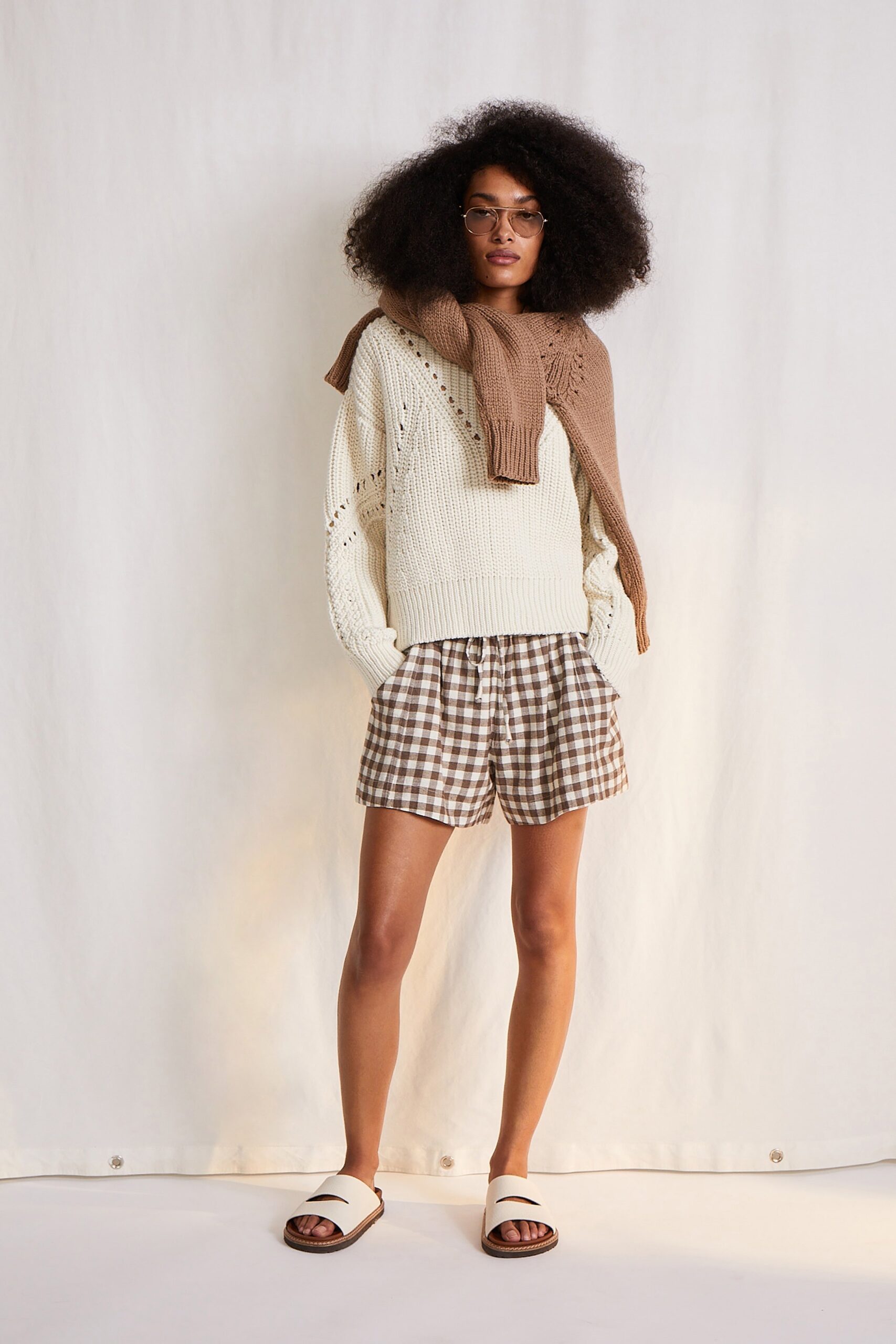 white relaxed knit sweater and brown checked shorts