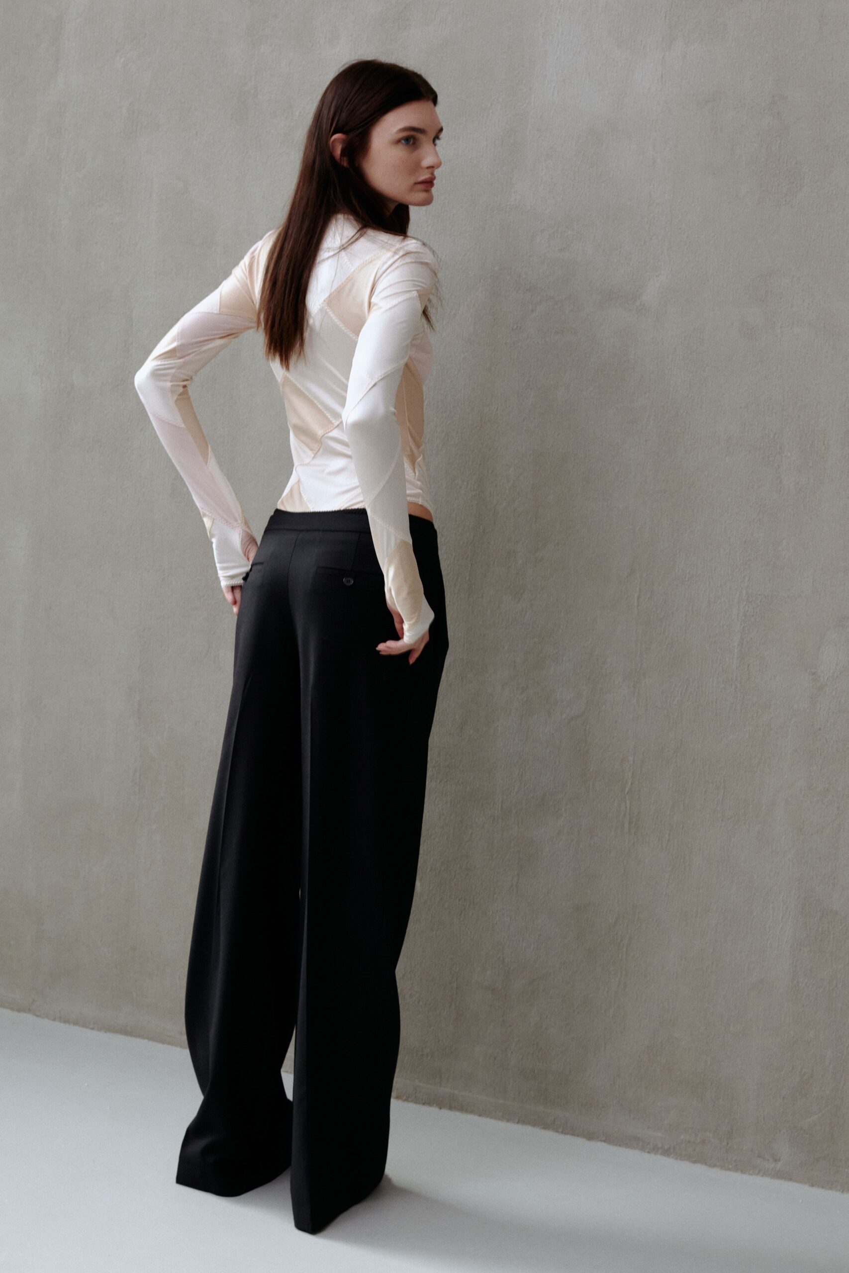 beige silk fitted top and black wide-leg pants
