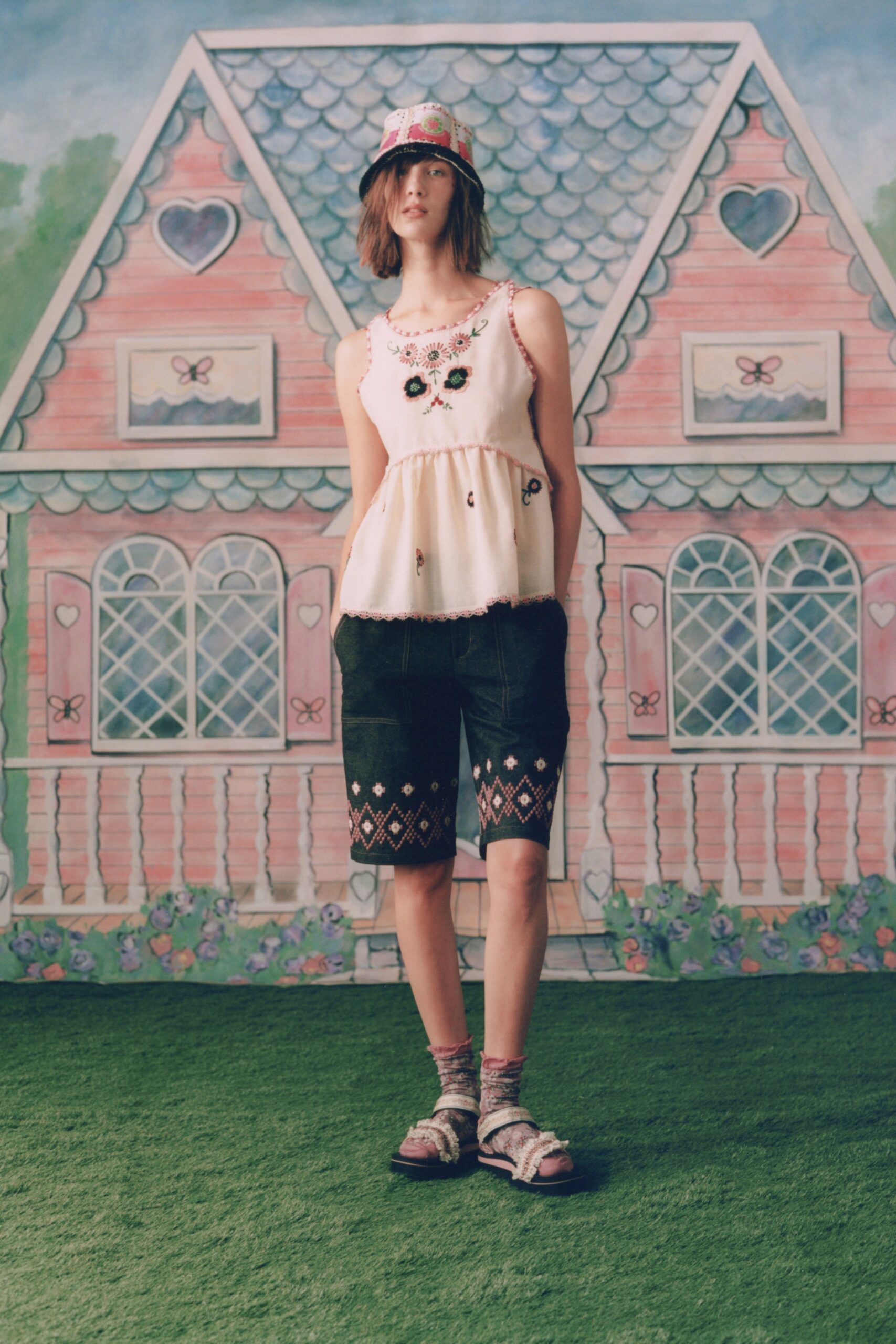 white embroidered sleeveless top and black shorts