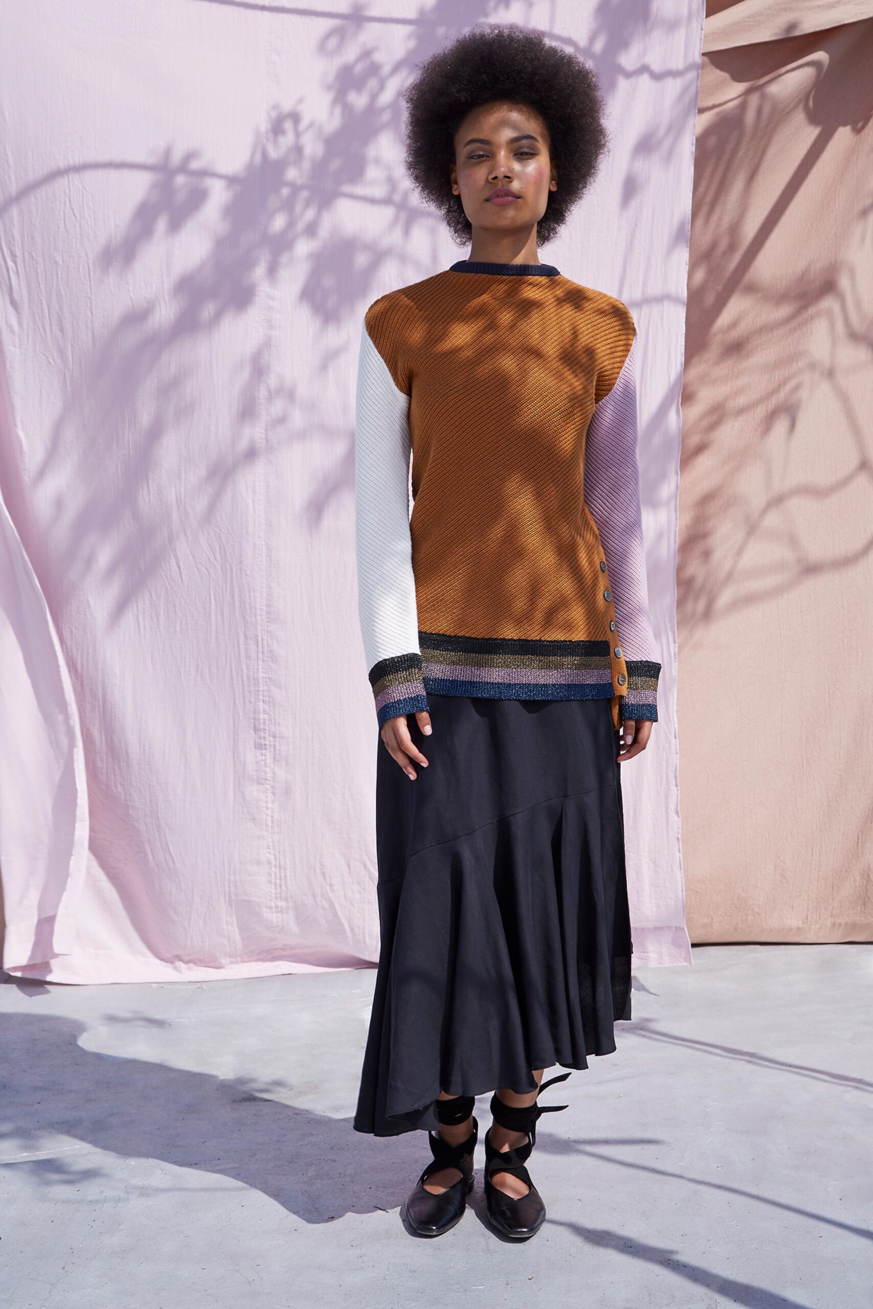 fitted brown and white top with black flared skirt