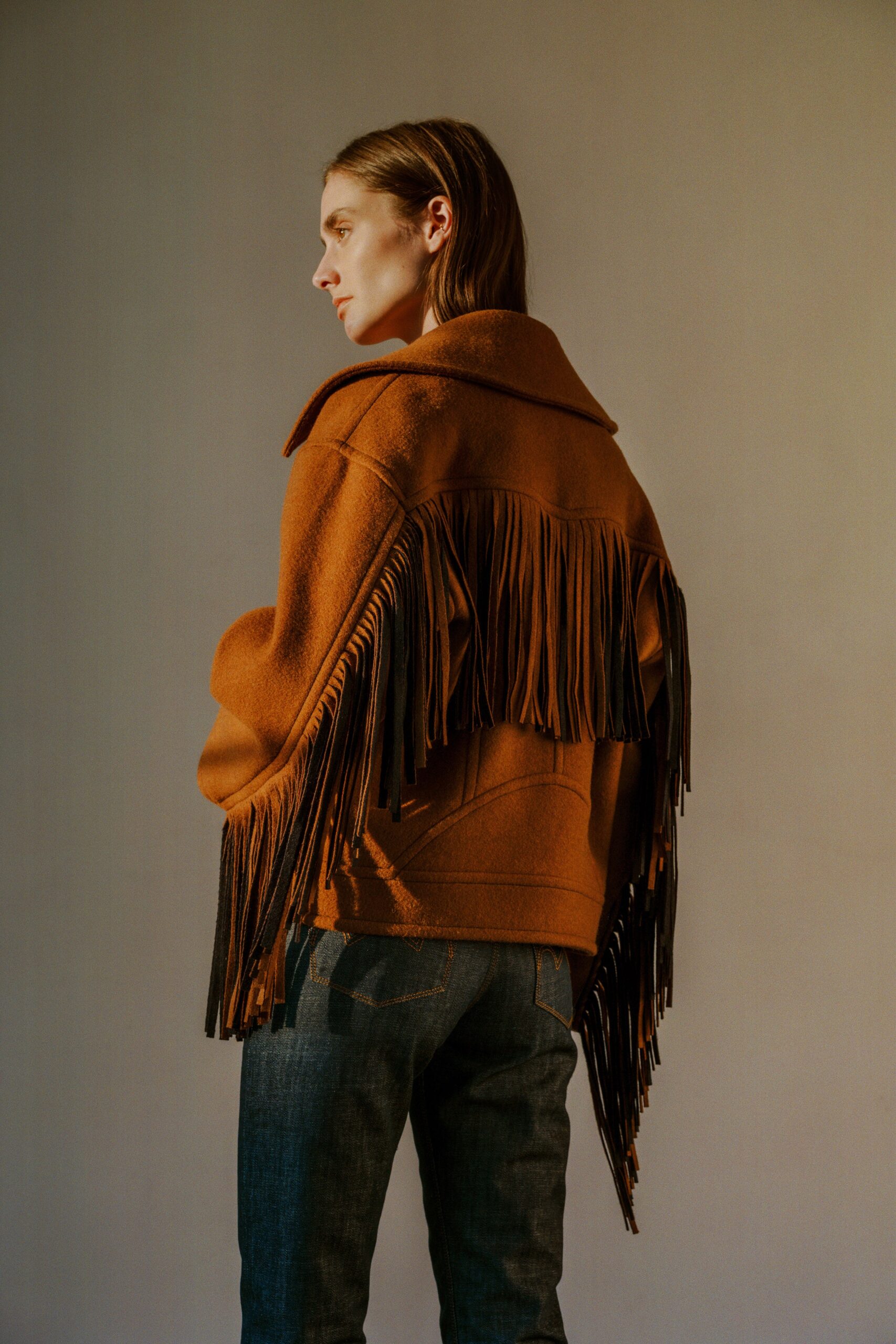 brown wool fringed jacket and blue denim pants