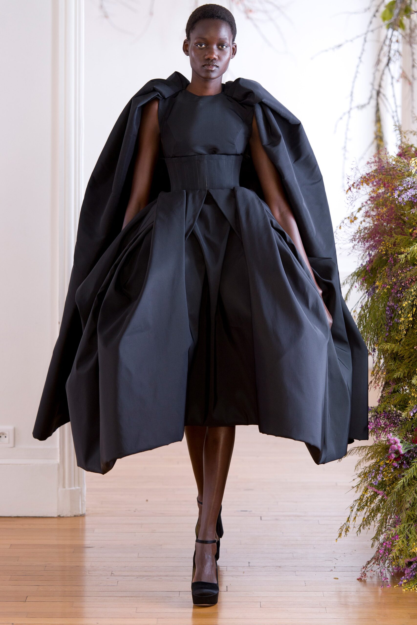 black fitted dress with oversized cape