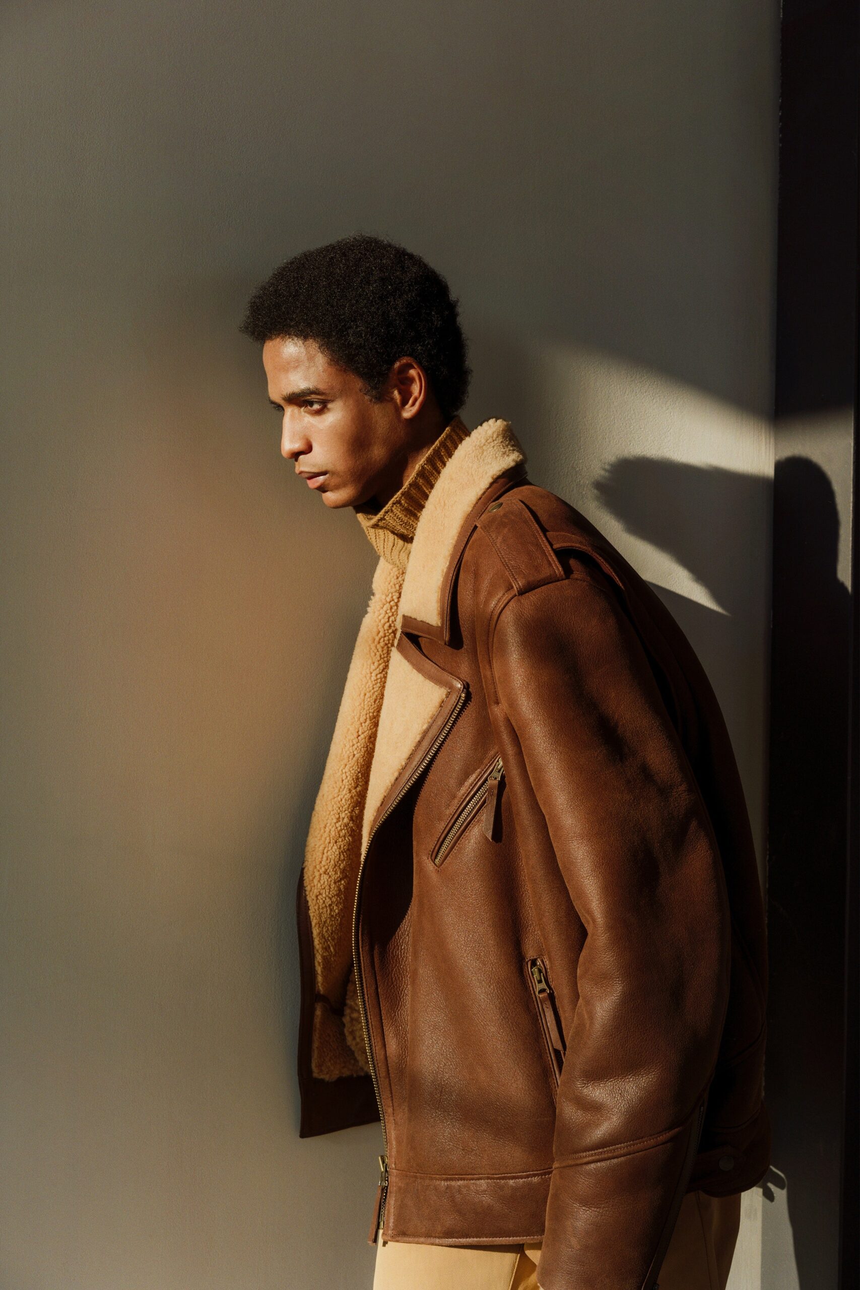brown leather oversized jacket and beige turtleneck sweater