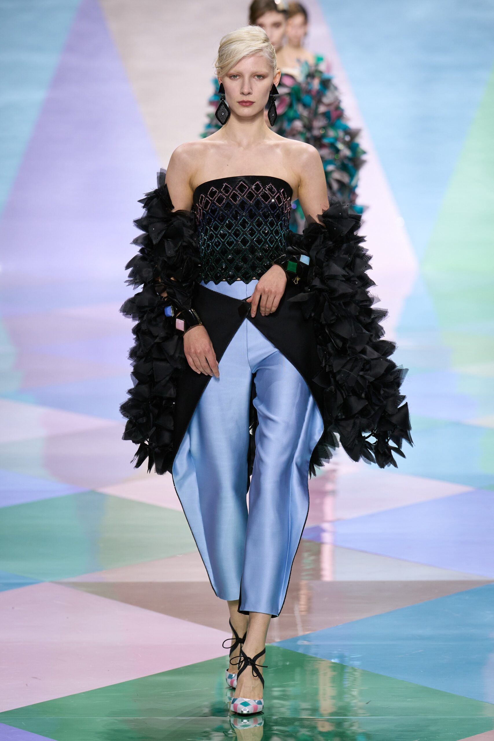 black ruffled strapless top with blue tailored pants