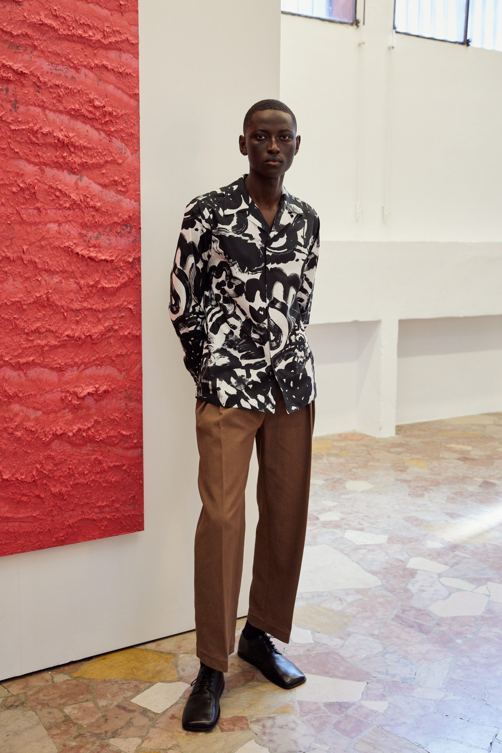 black and white printed shirt with brown tailored pants