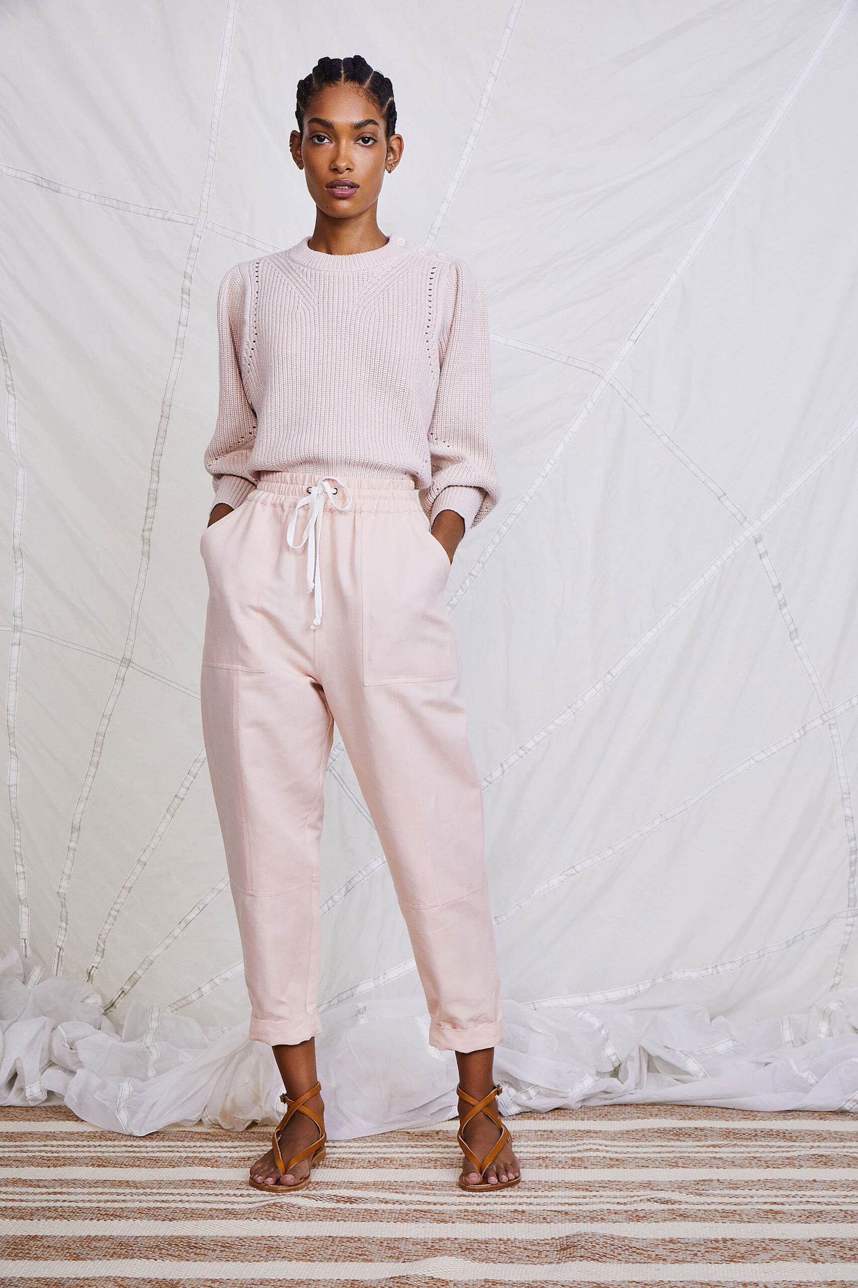 pink relaxed sweater and beige pants