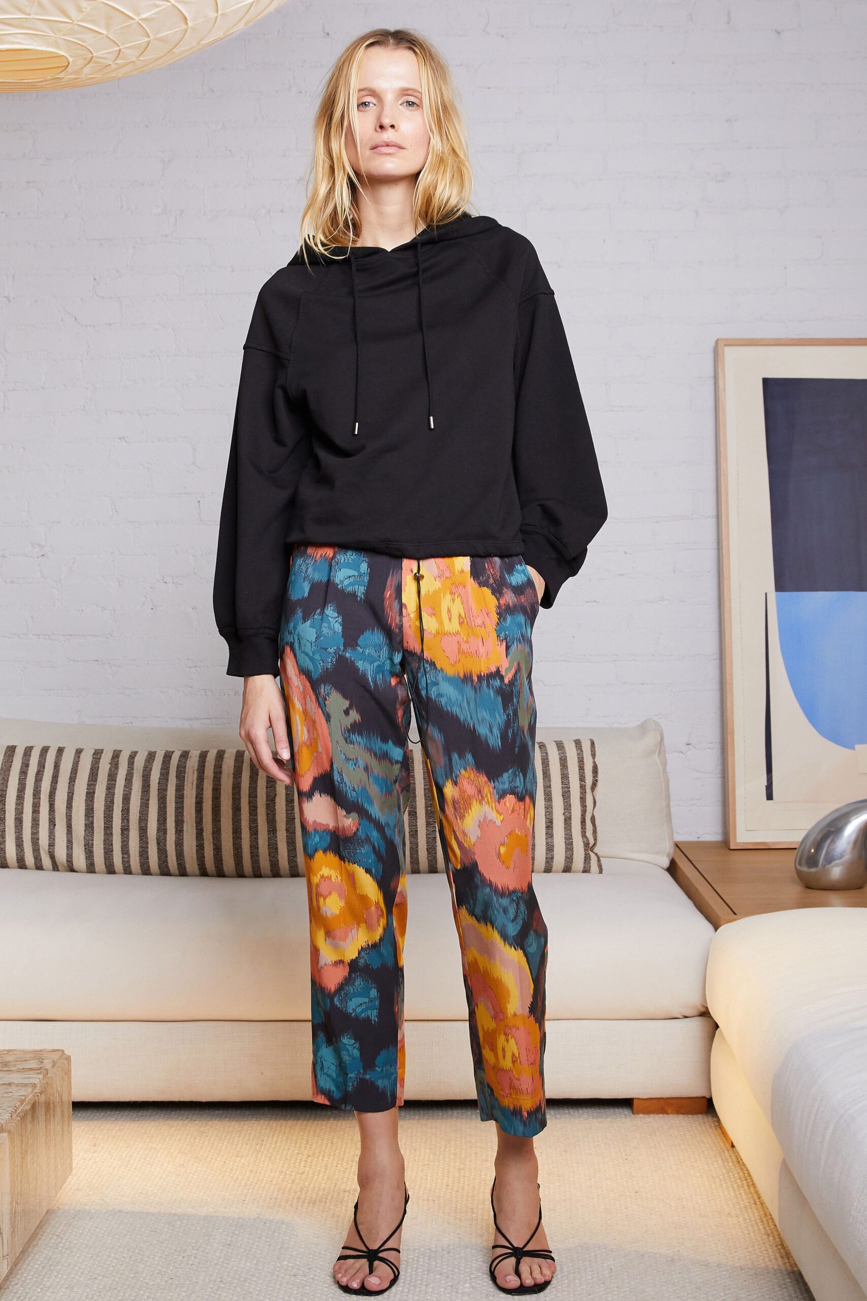 black hoodie with multi-colored pants